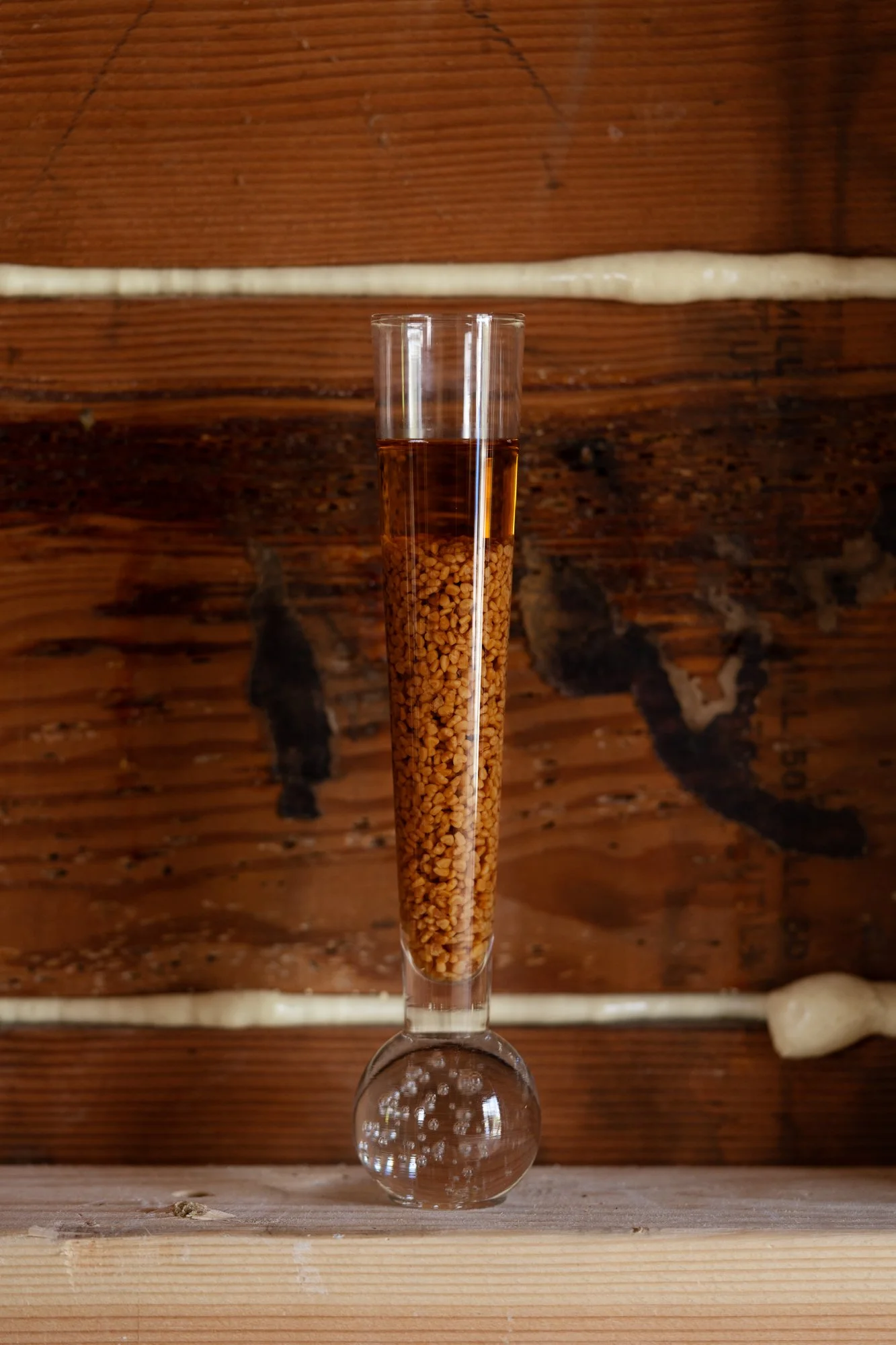 a glass vessel with orange substances inside