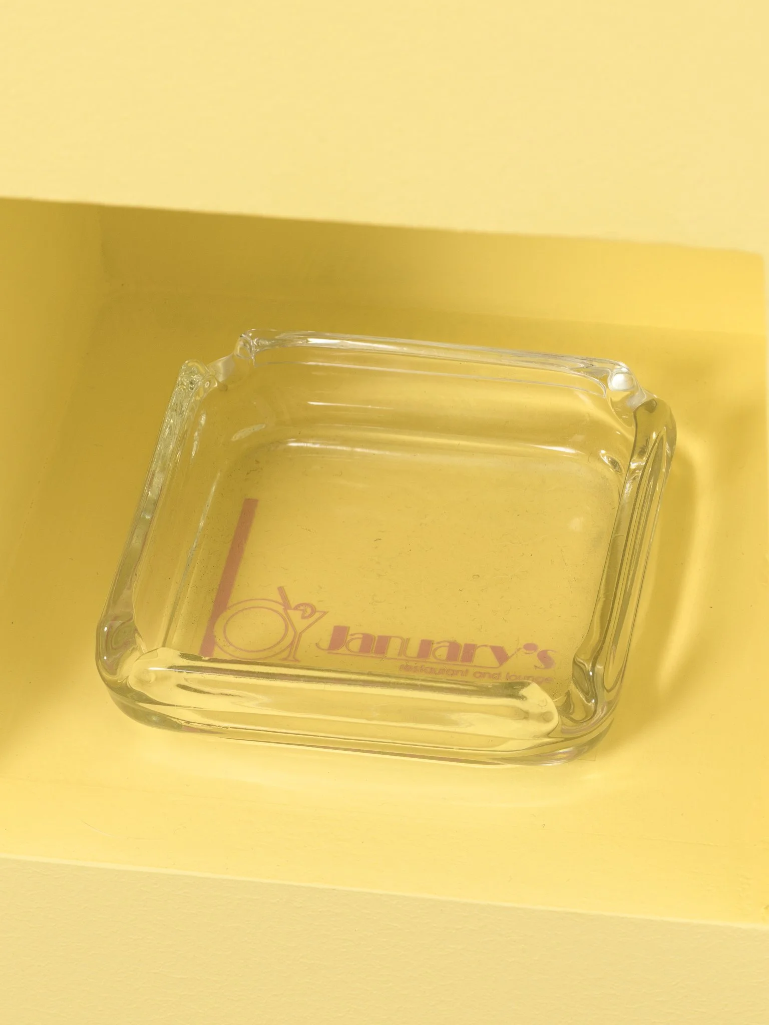 a glass cigarette tray in a yellow box