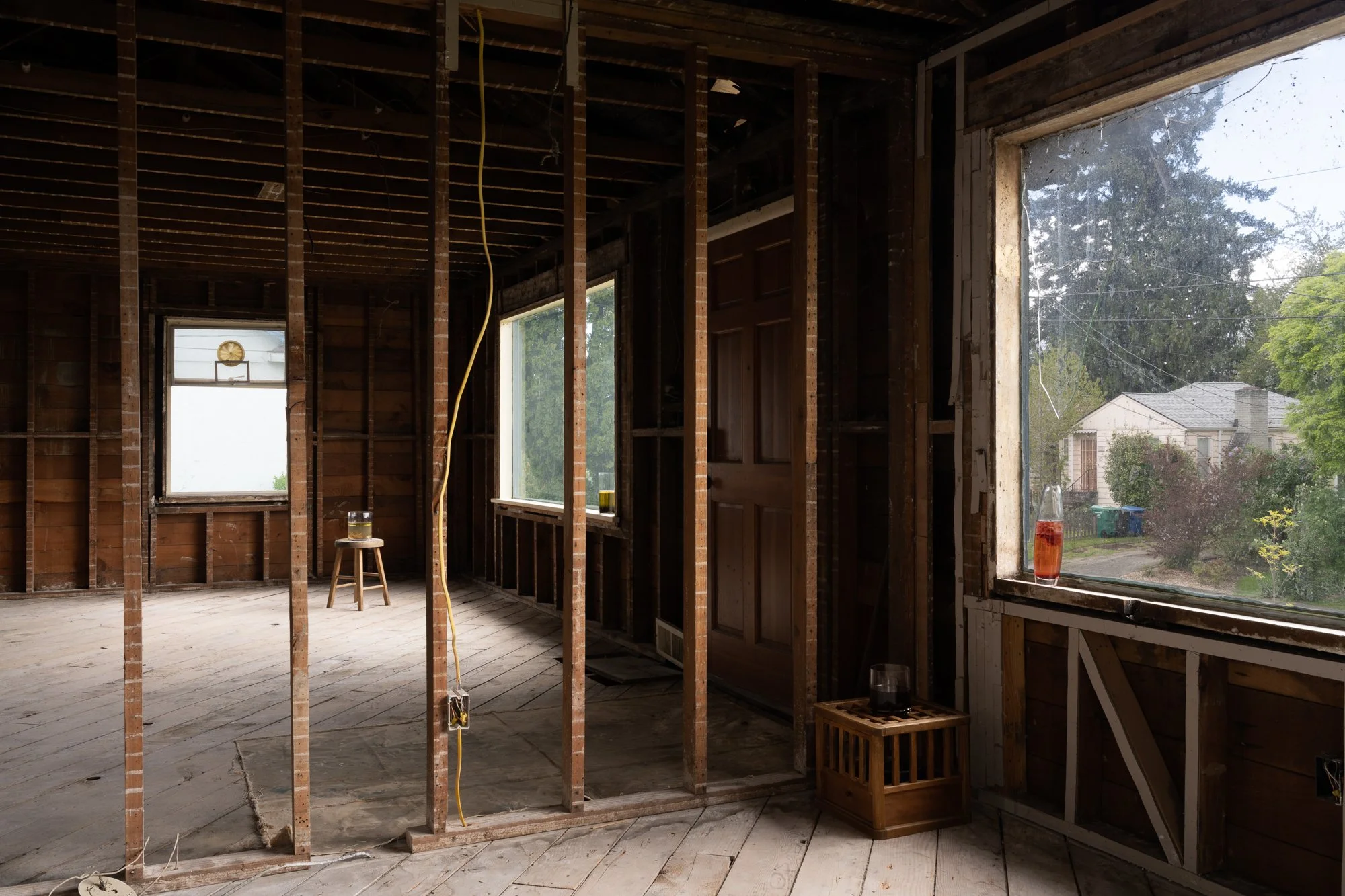 various glass vessels with liquids in an empty room without drywalls
