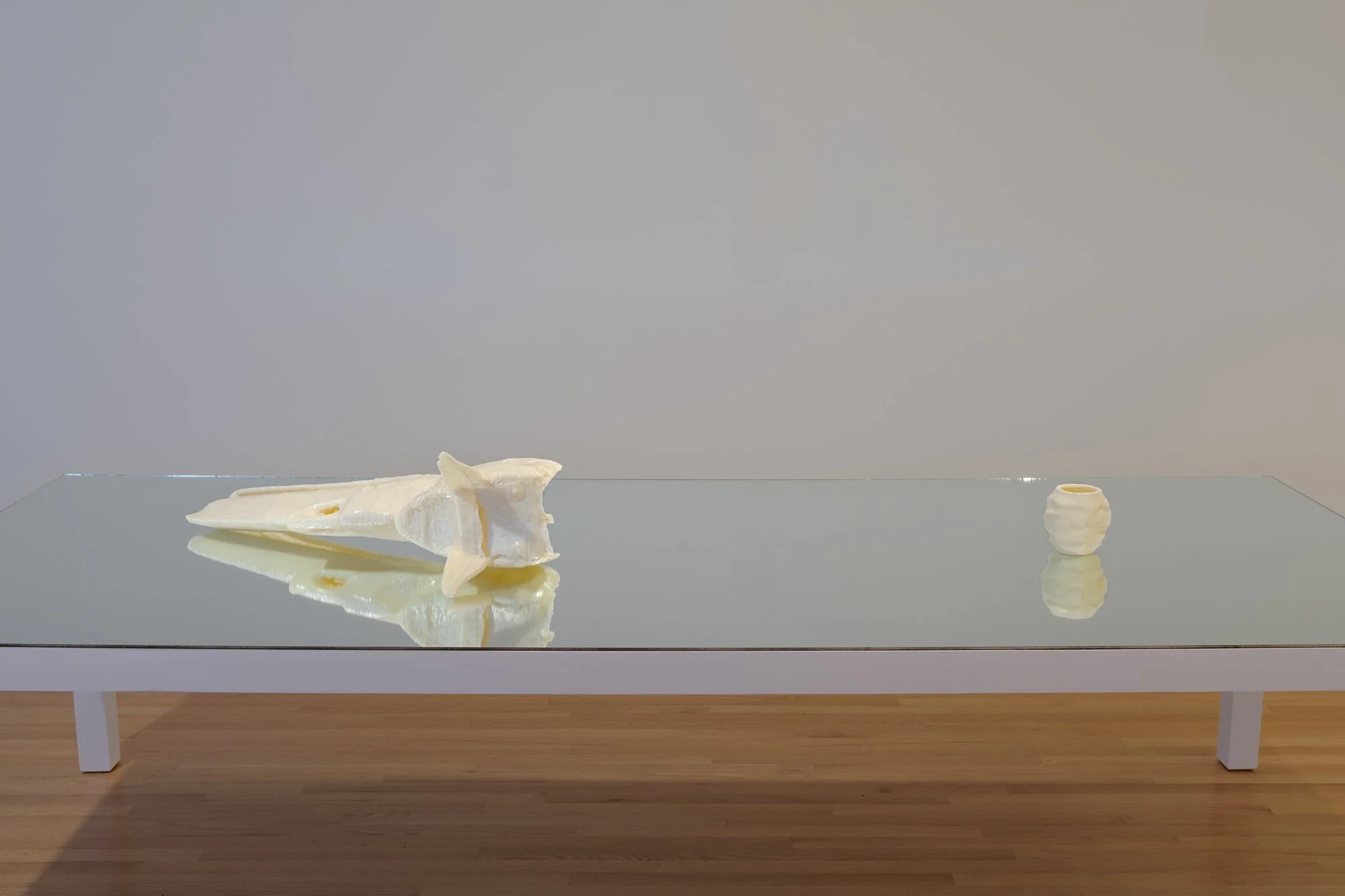 two 3D printed sculptures on a table with a mirror top