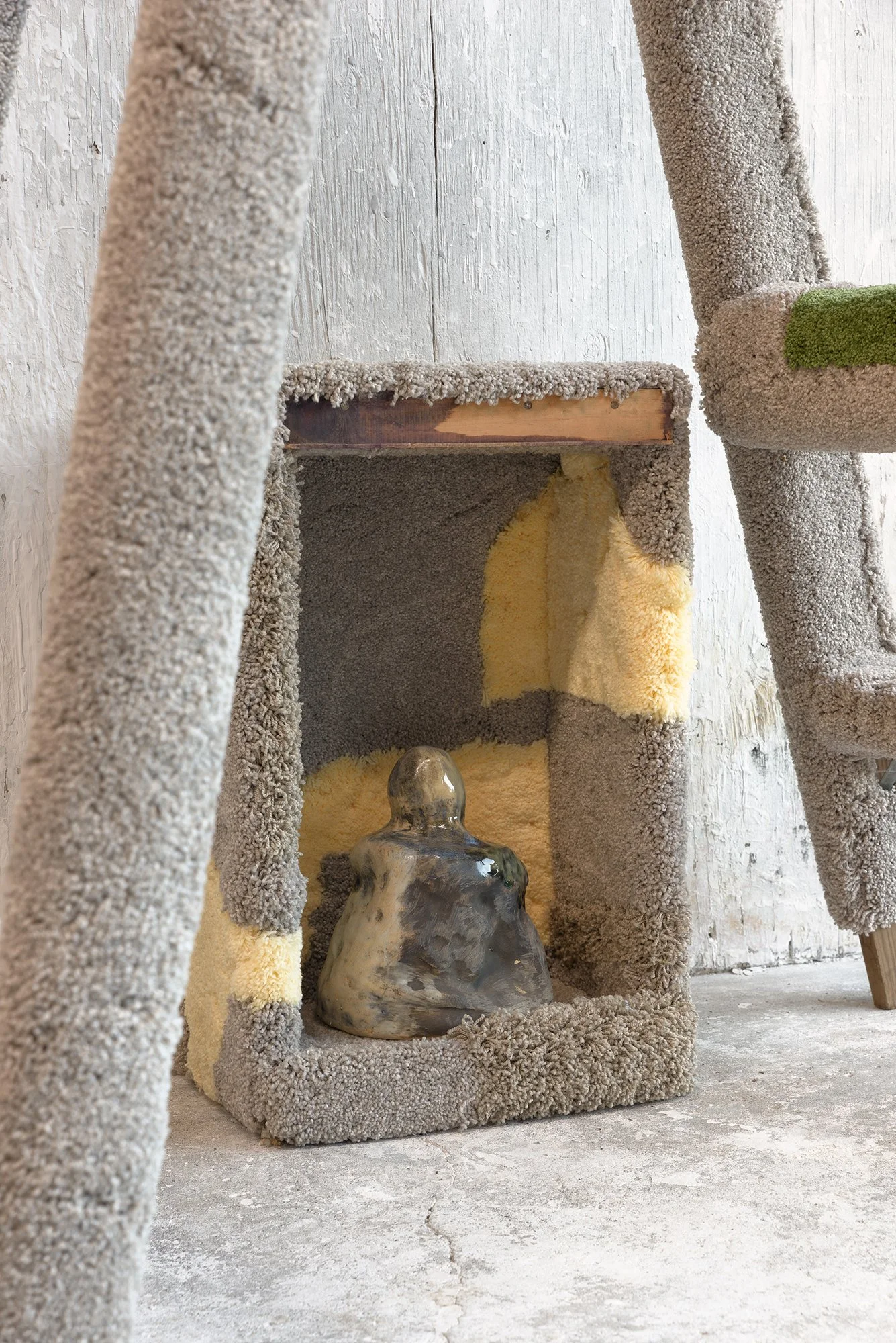 a ceramic bell sitting inside a wooden box covered with carpet