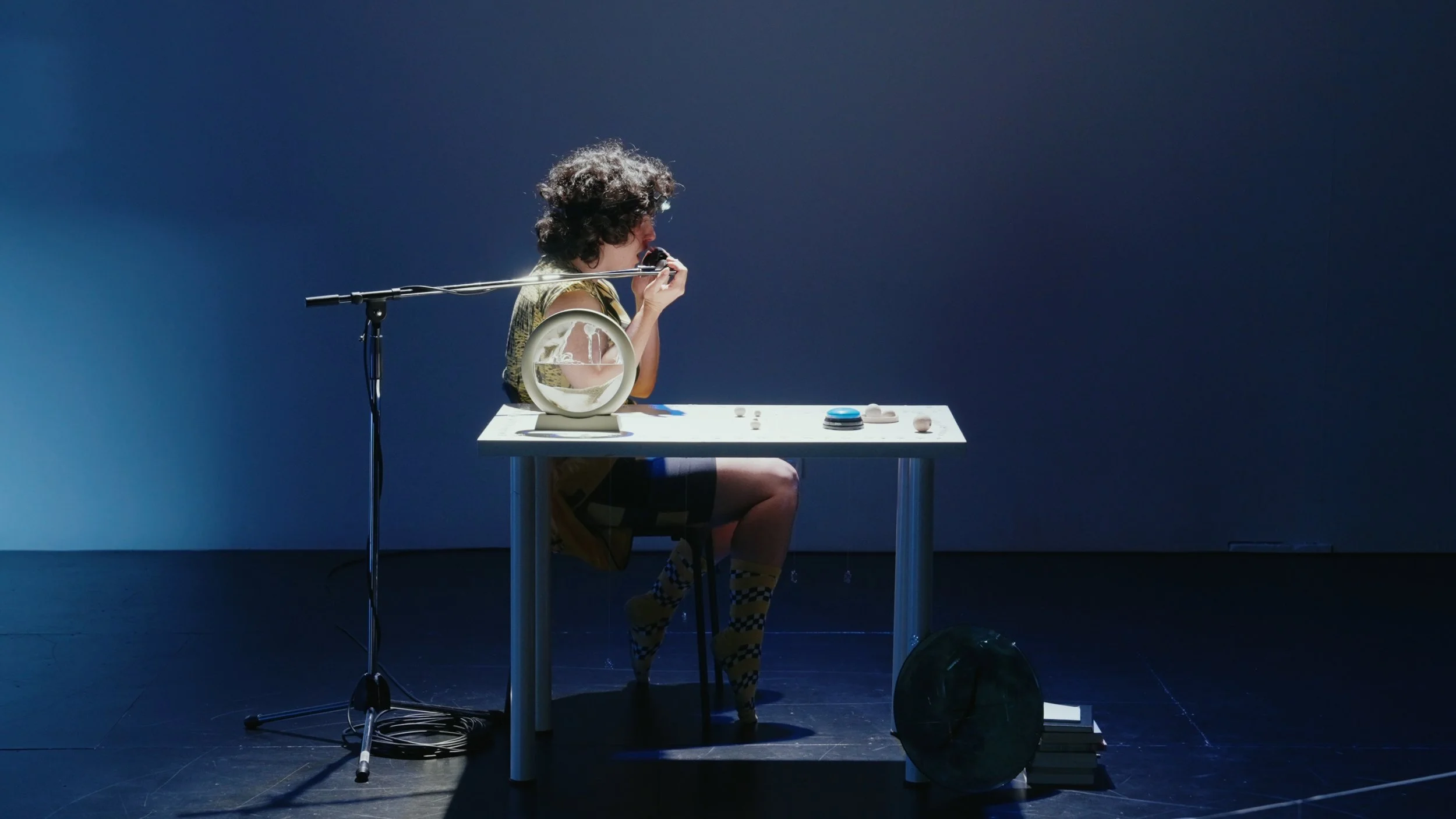 a performer singing with a mic in frong of a blue wall