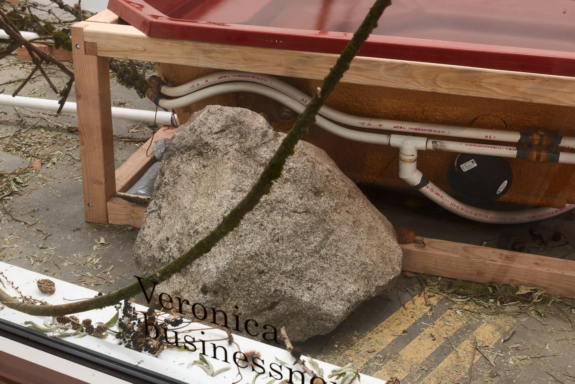 a large boulder next to a red hot tub