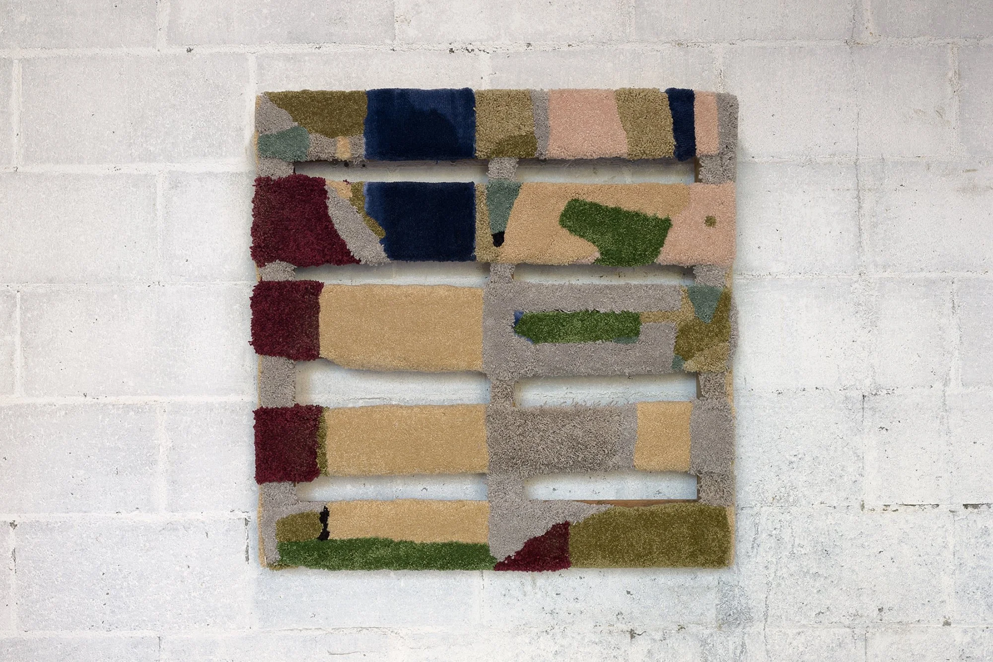 a wood pallet covered with various carpet scraps