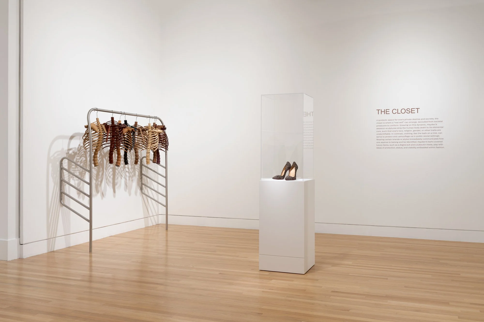 a pair of heels on a podium; many skeletons on a rack