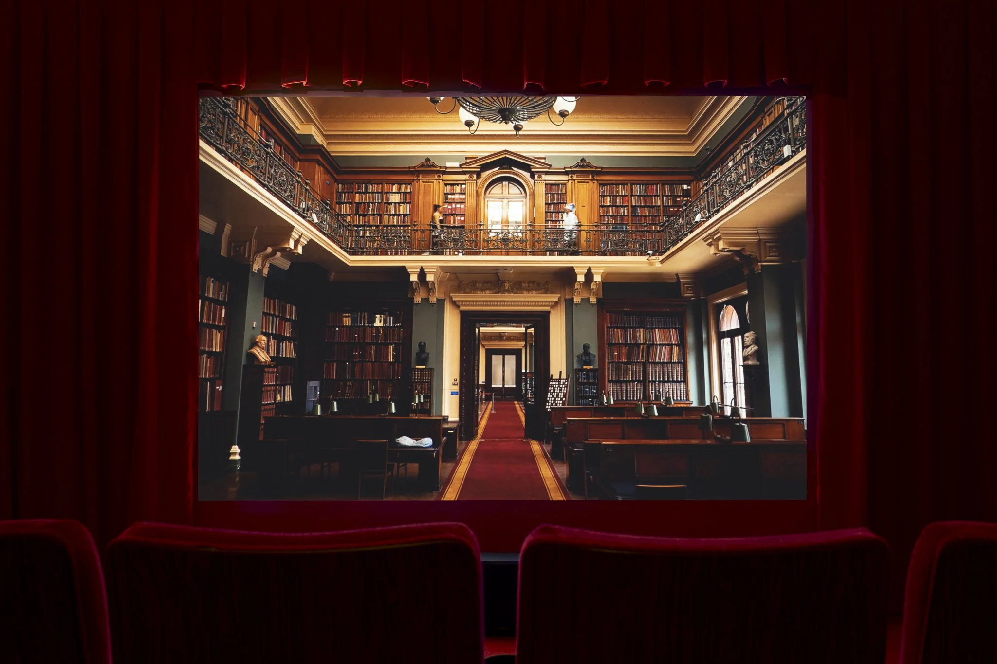 a video in a red theater showing a library