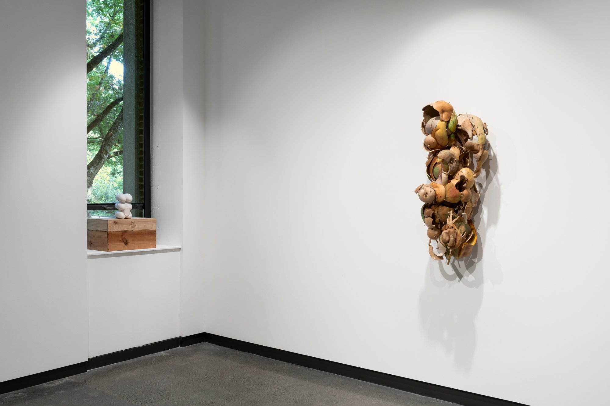 a large sculpture on the wall; a small sculpture on the window sill