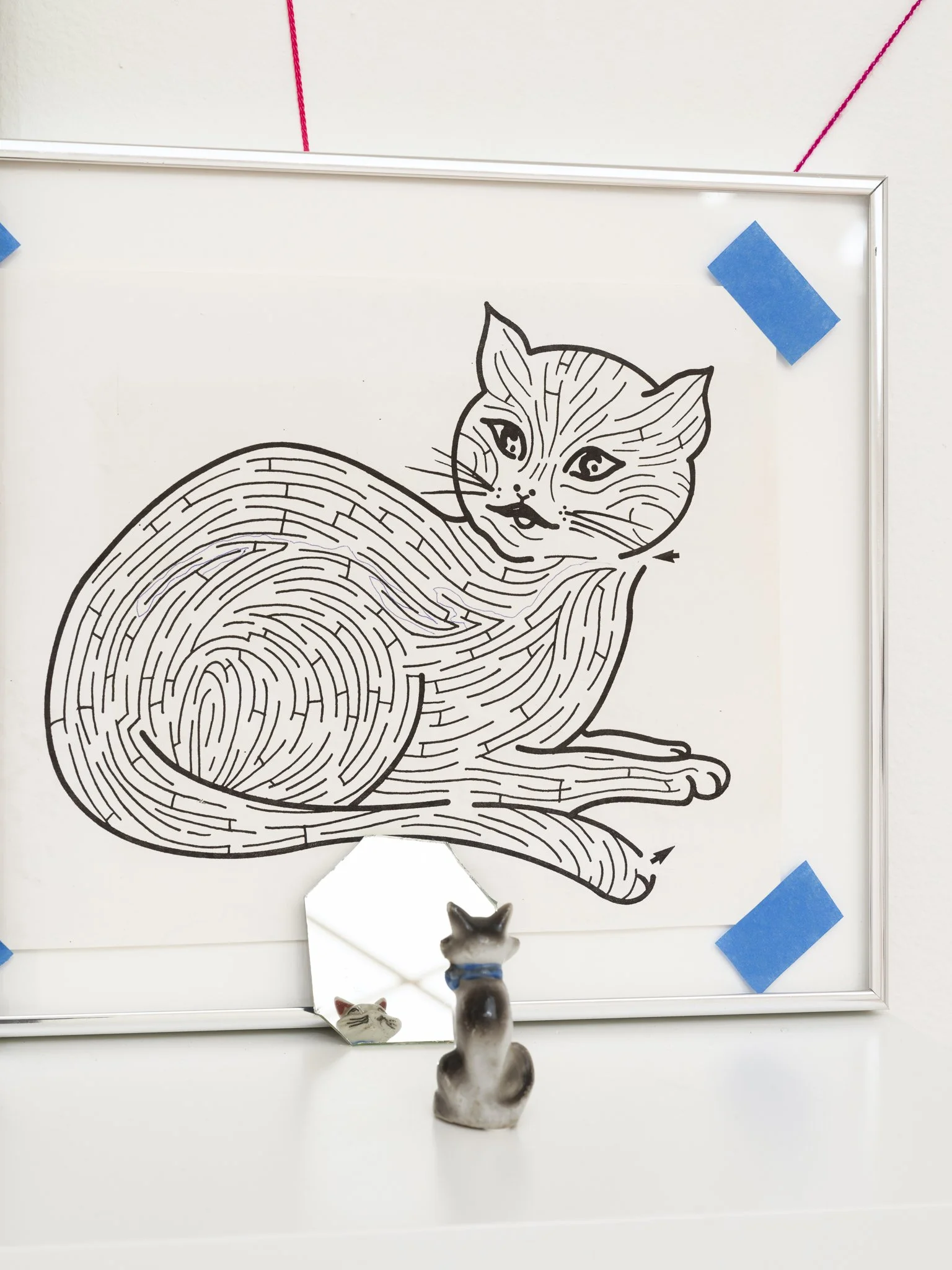a small cat sculpture in front of a cat maze