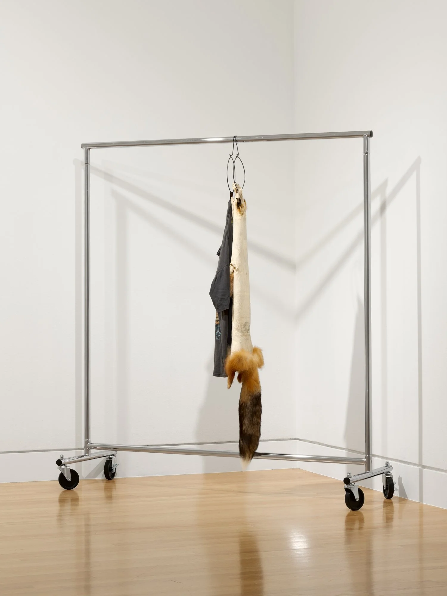 a fox skin and a t-shirt hung on a clothes rack