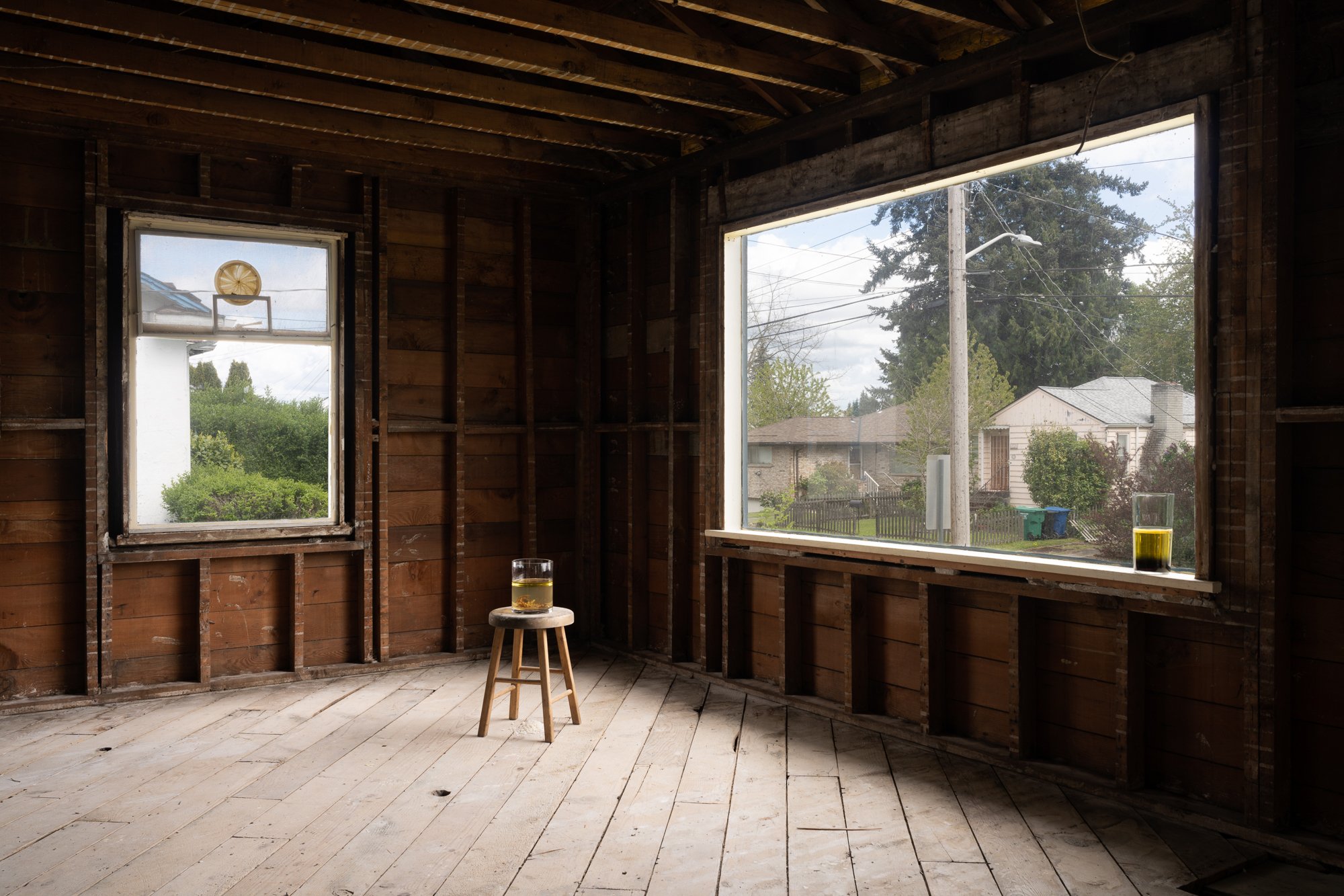 two glass vessels with liquids in an empty living room without drywalls