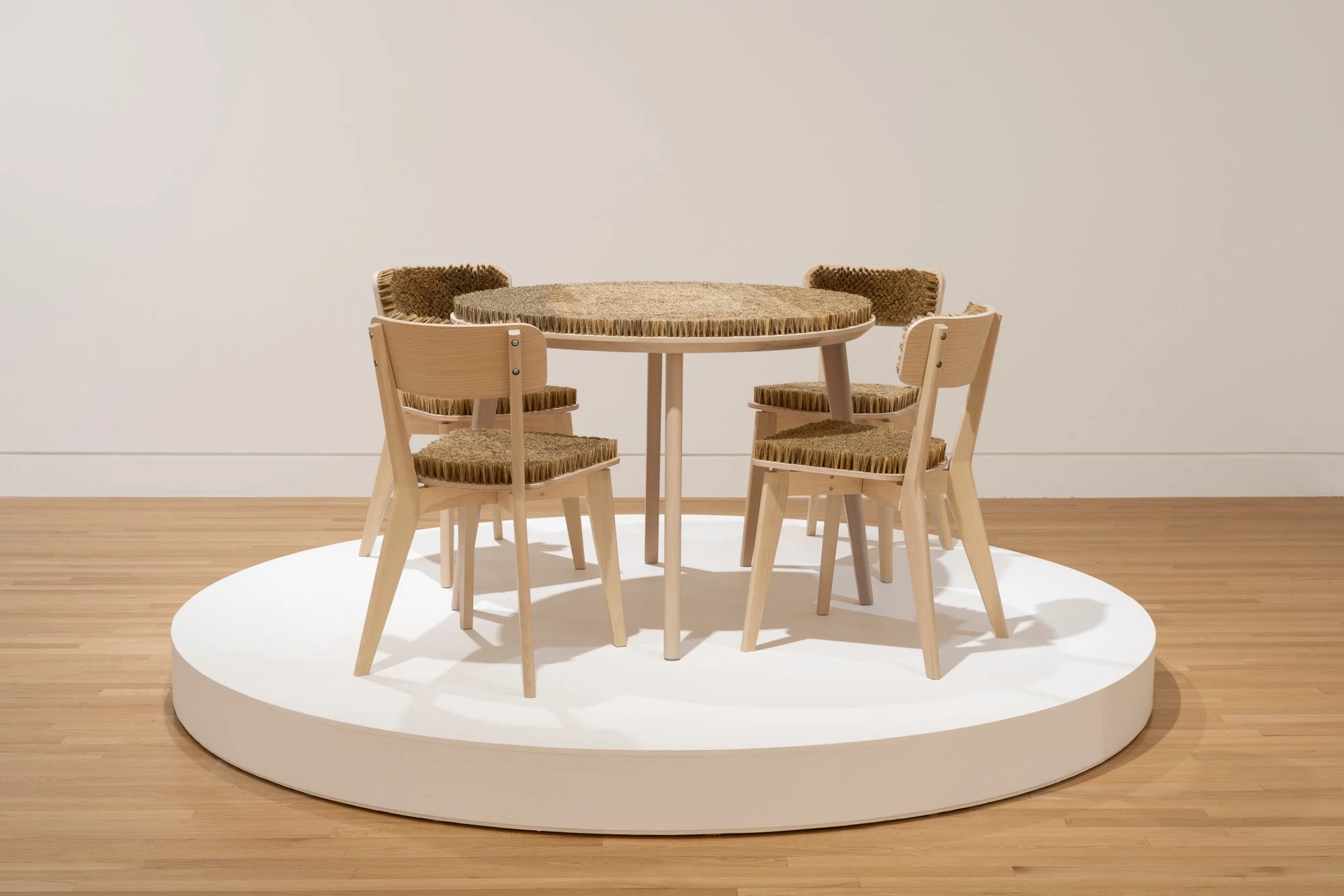 a table with 4 chairs, all with brushes as the top surface