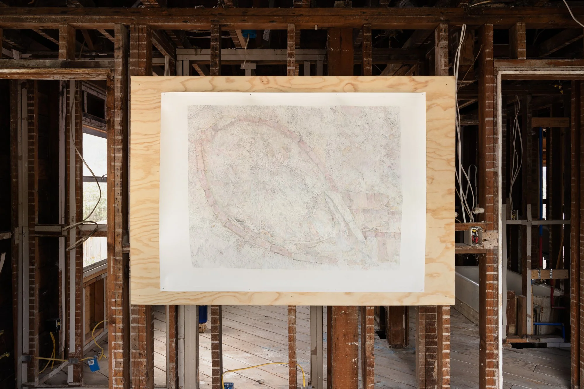 a large drawing on a piece of plywood attached to bare studs