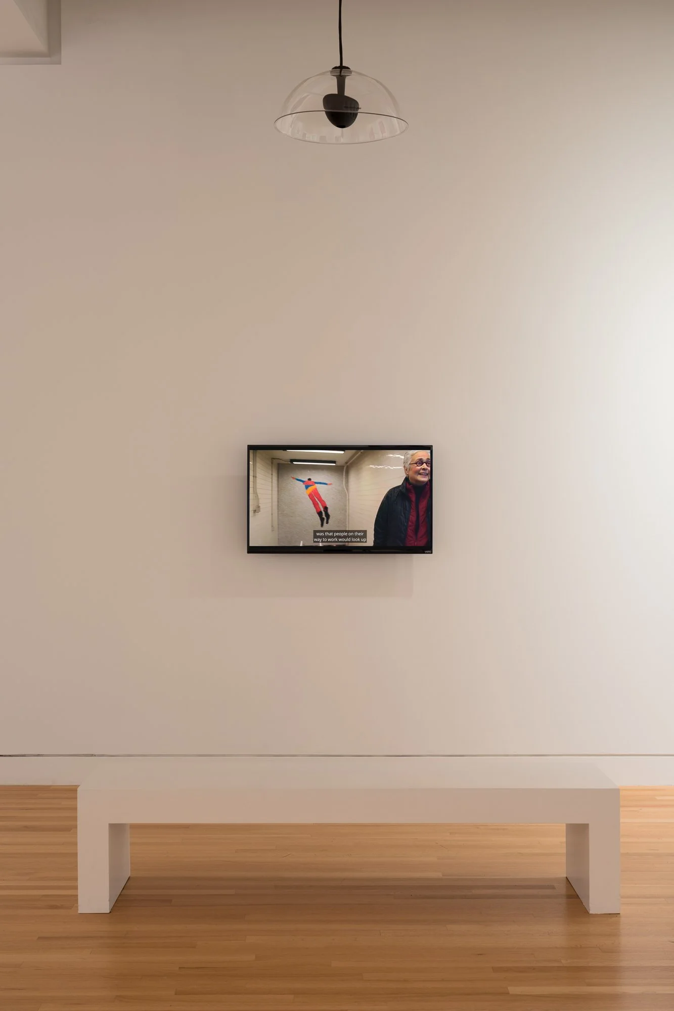a overhead speaker, a TV playing a video, and a bench