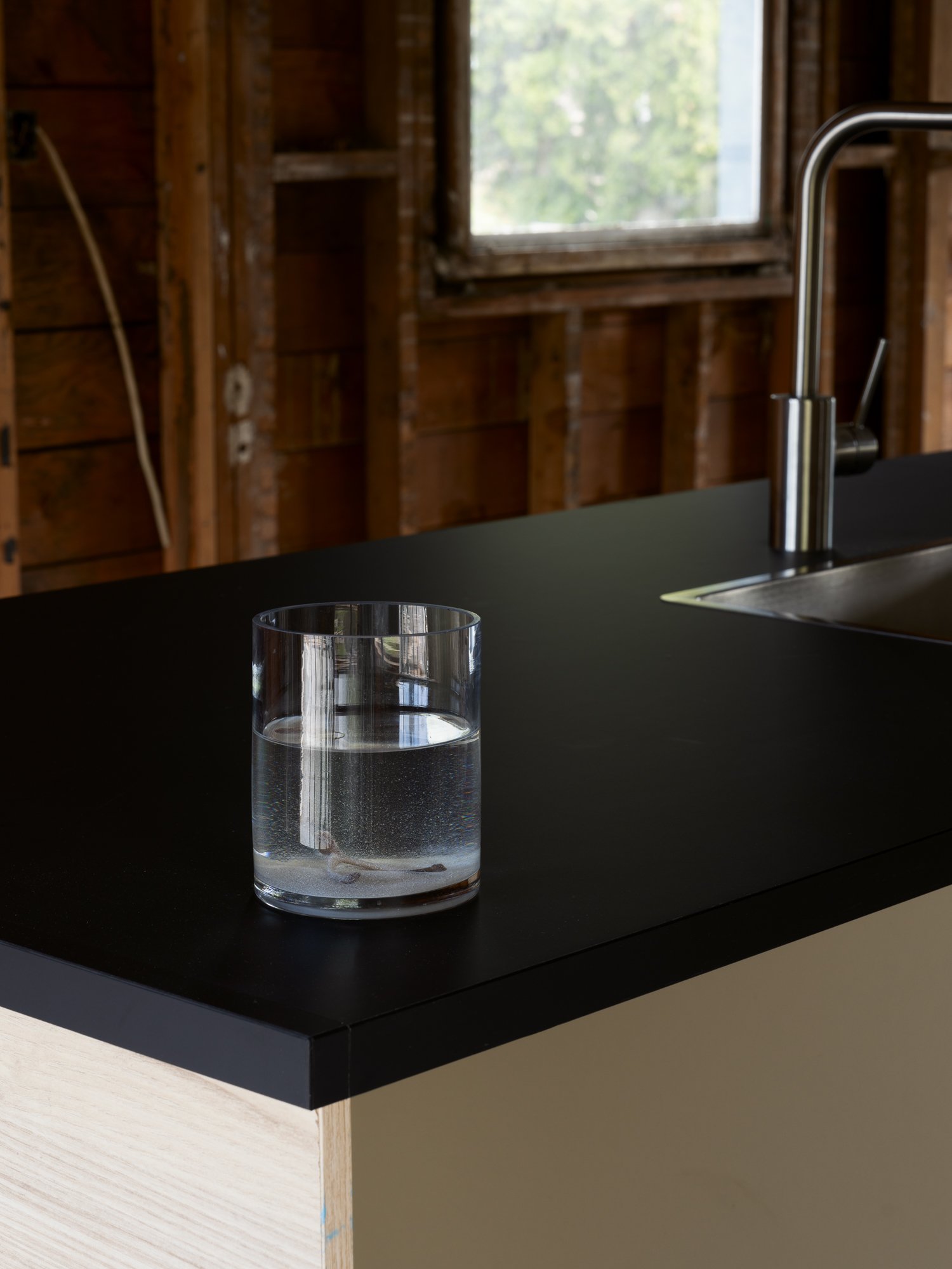 a glass vase with clear liquid on a kitchen counter