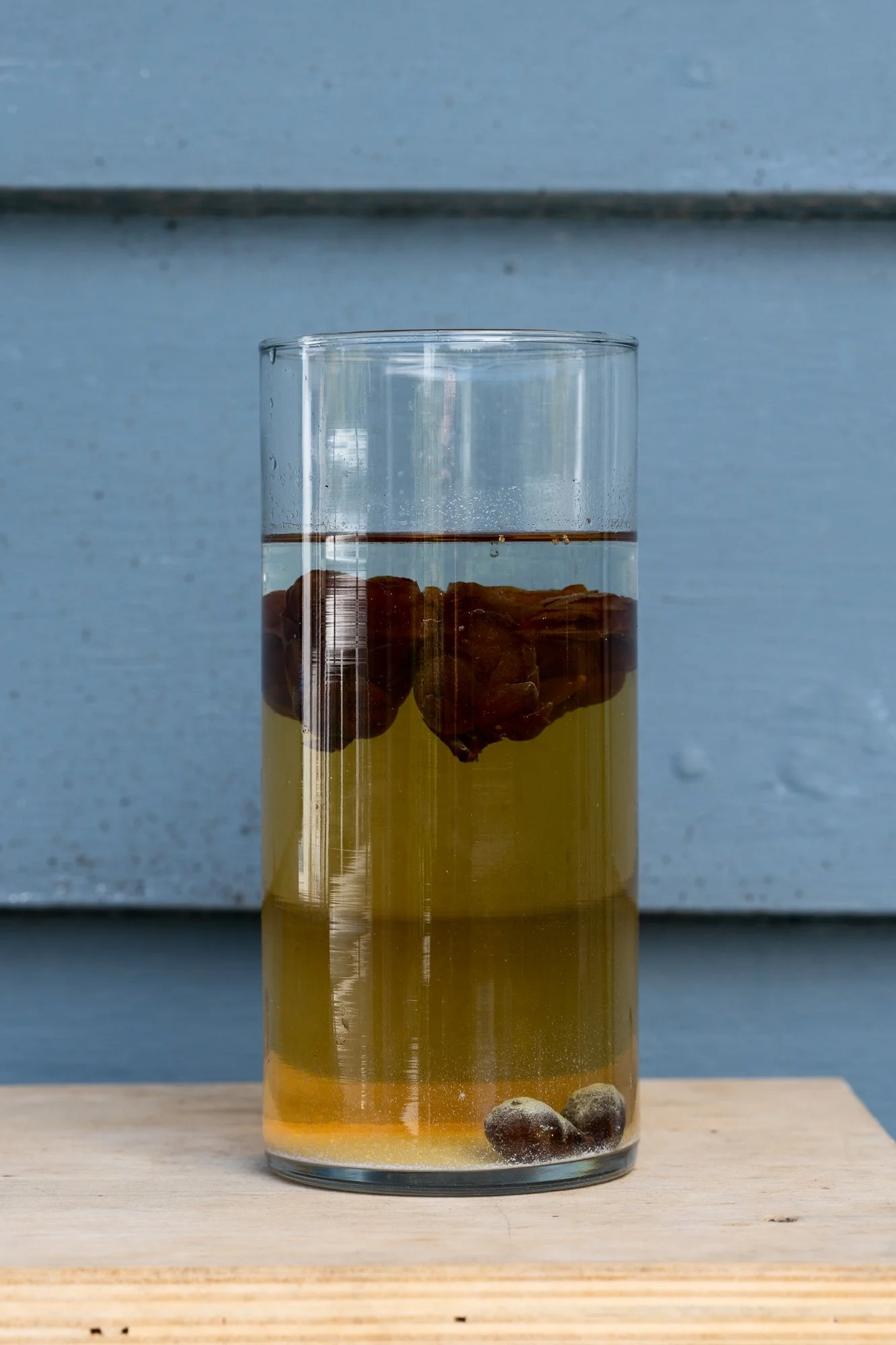 a glass vase with various substances on a wire shelf