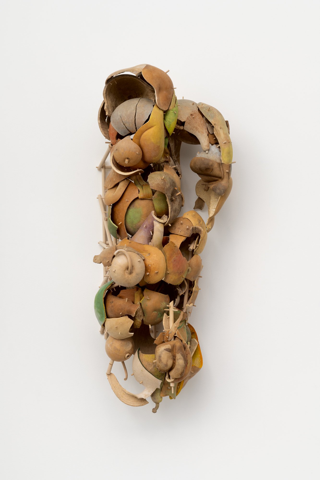 a large sculpture made of gourds on a white wall