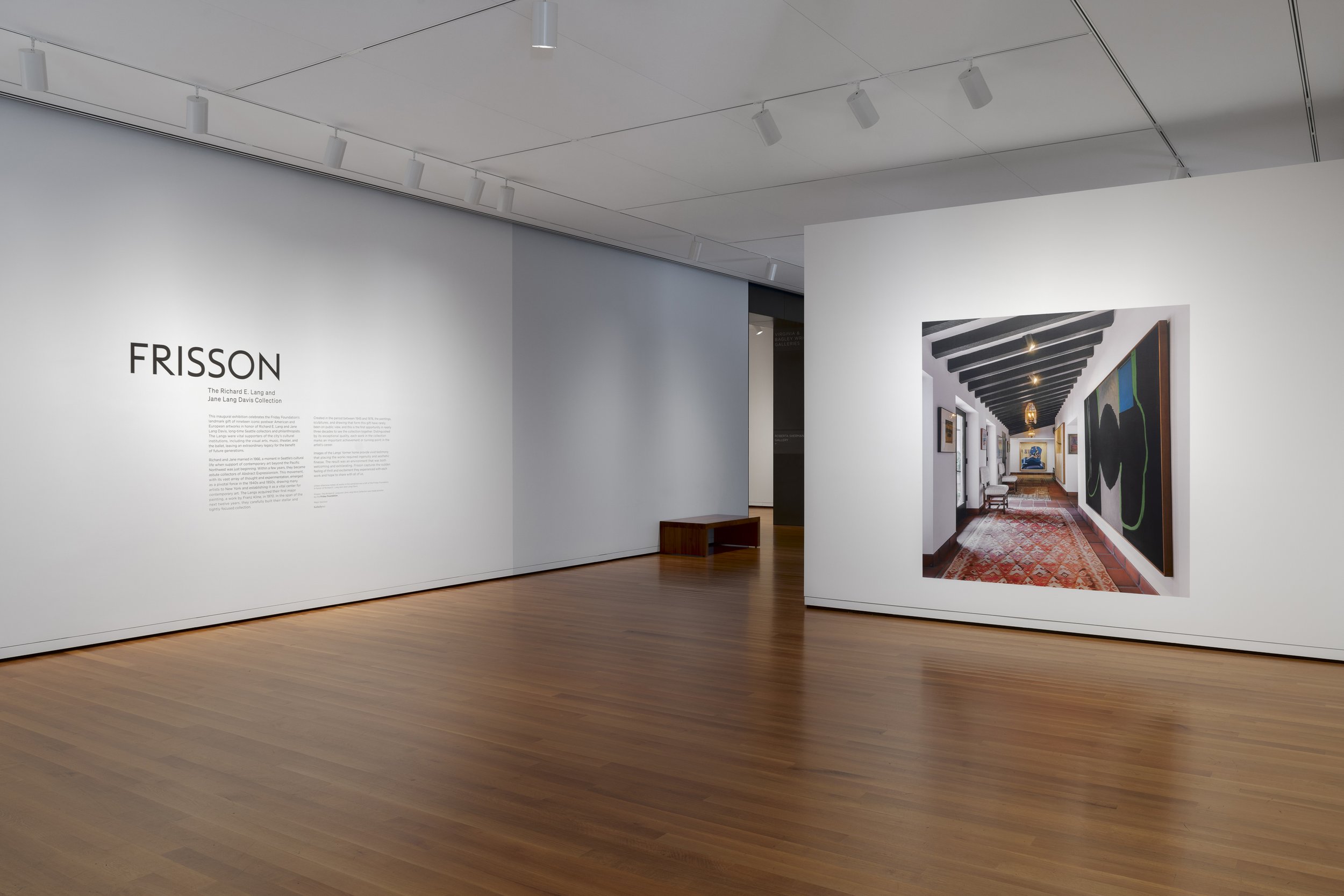 a wall with a photo of a house interior; a wall with vinyl text.