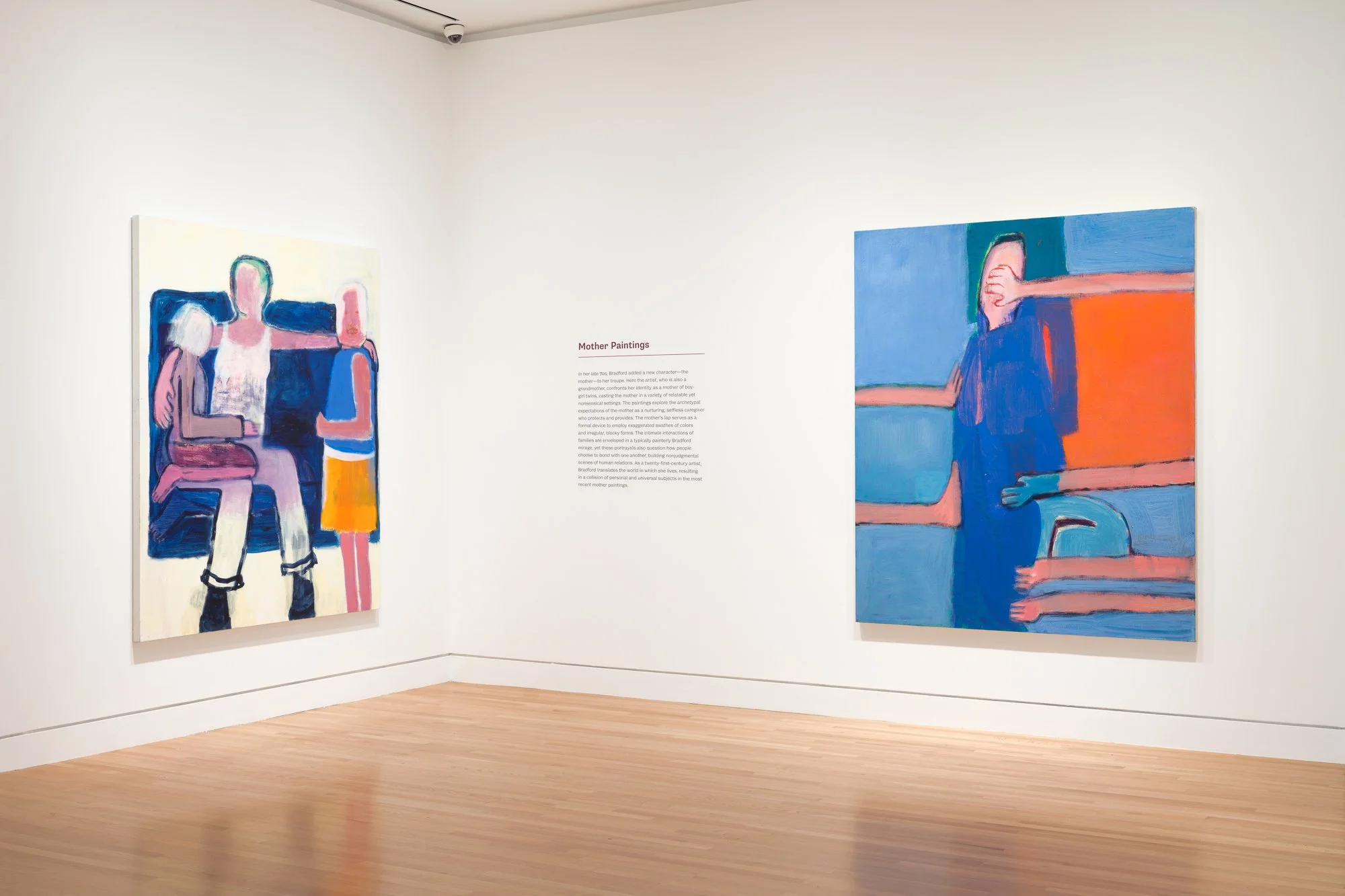 two colorful paintings of figures and wall text