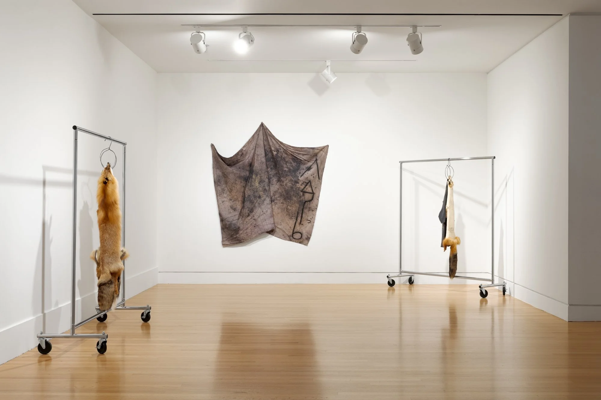 two sculptures and a textile artwork in a gallery