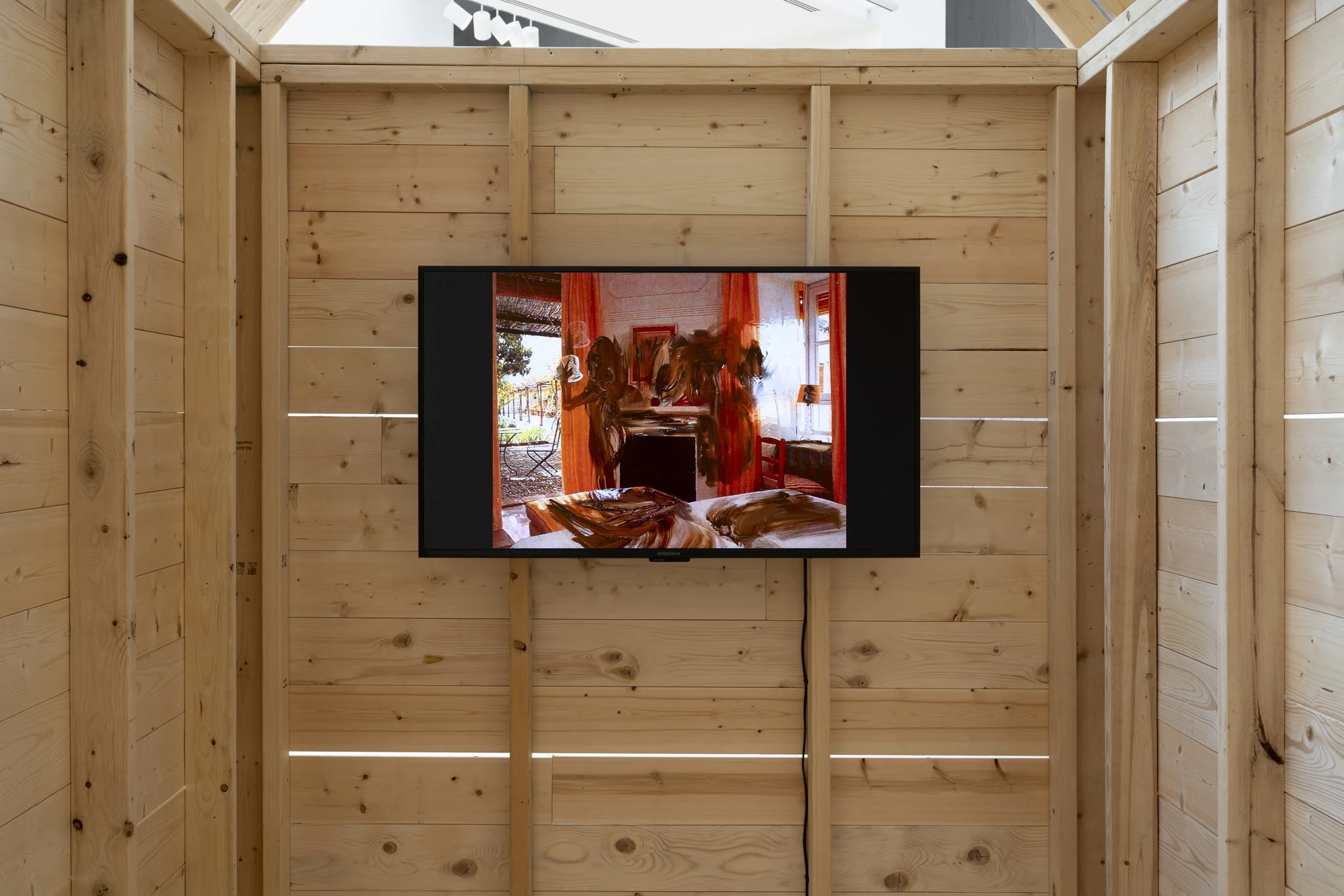 a wooden shed with a video screen showing a red room