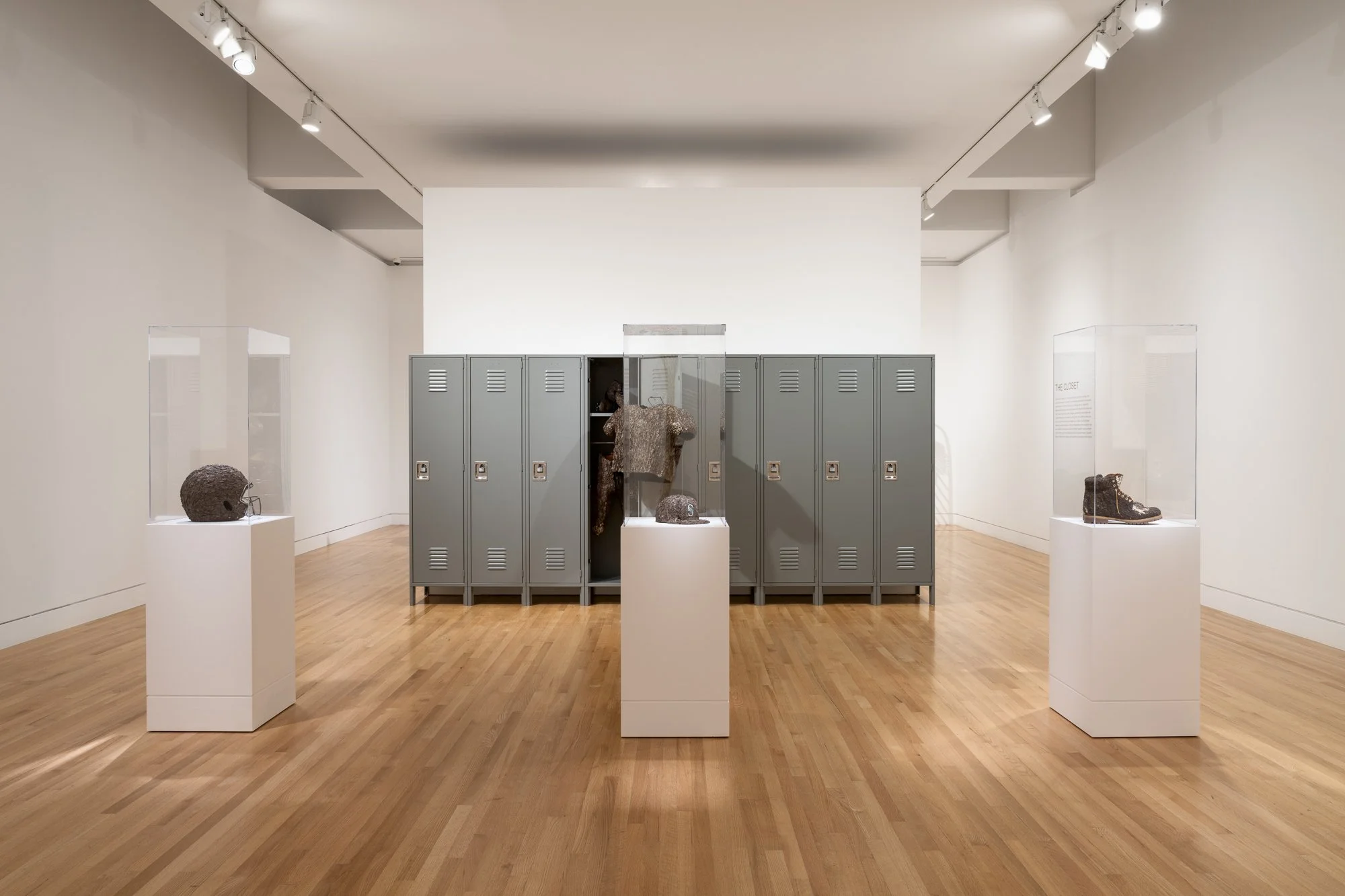 various sculptures and a roll of lockers in a gallery