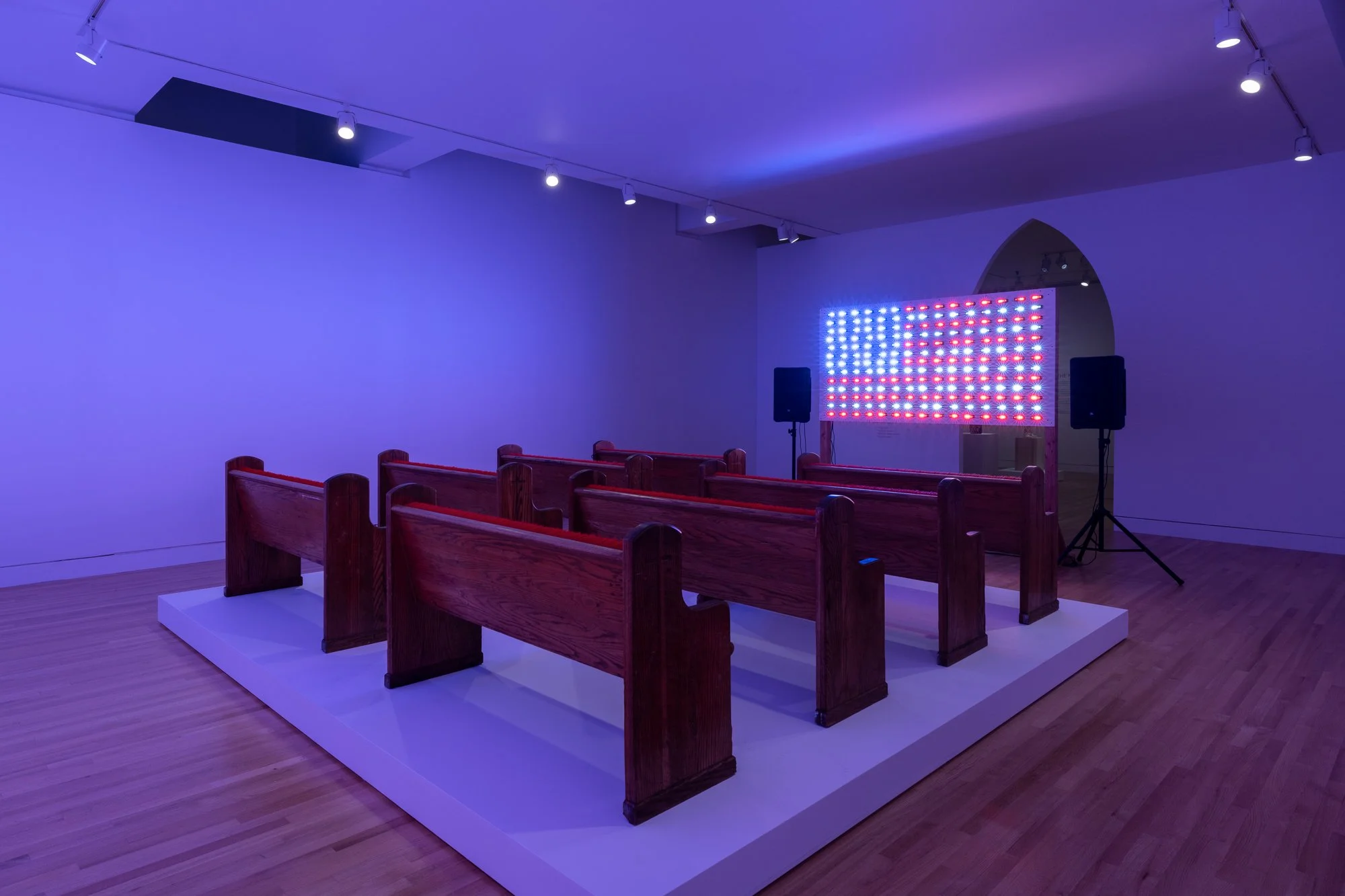 an LED panel showing an american flag in front of church pews