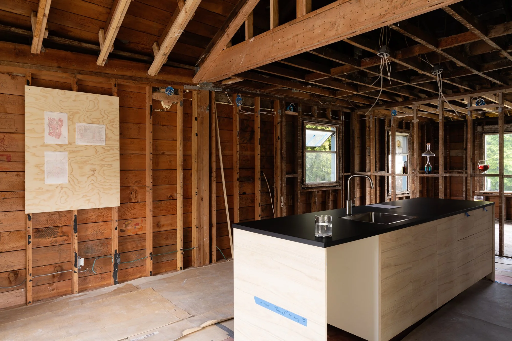 a kitchen under construction with various artworks