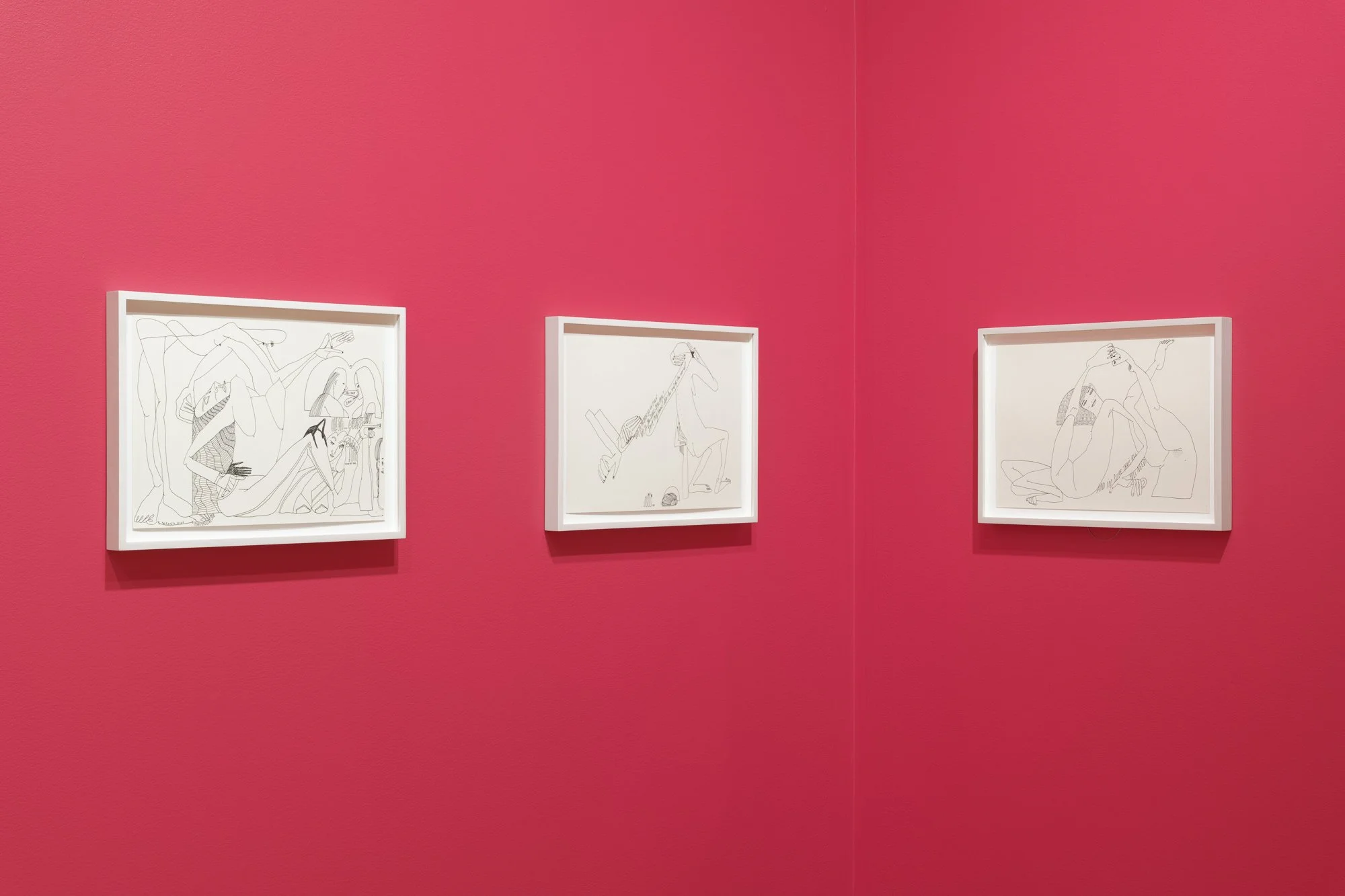 three abstract drawings on red walls
