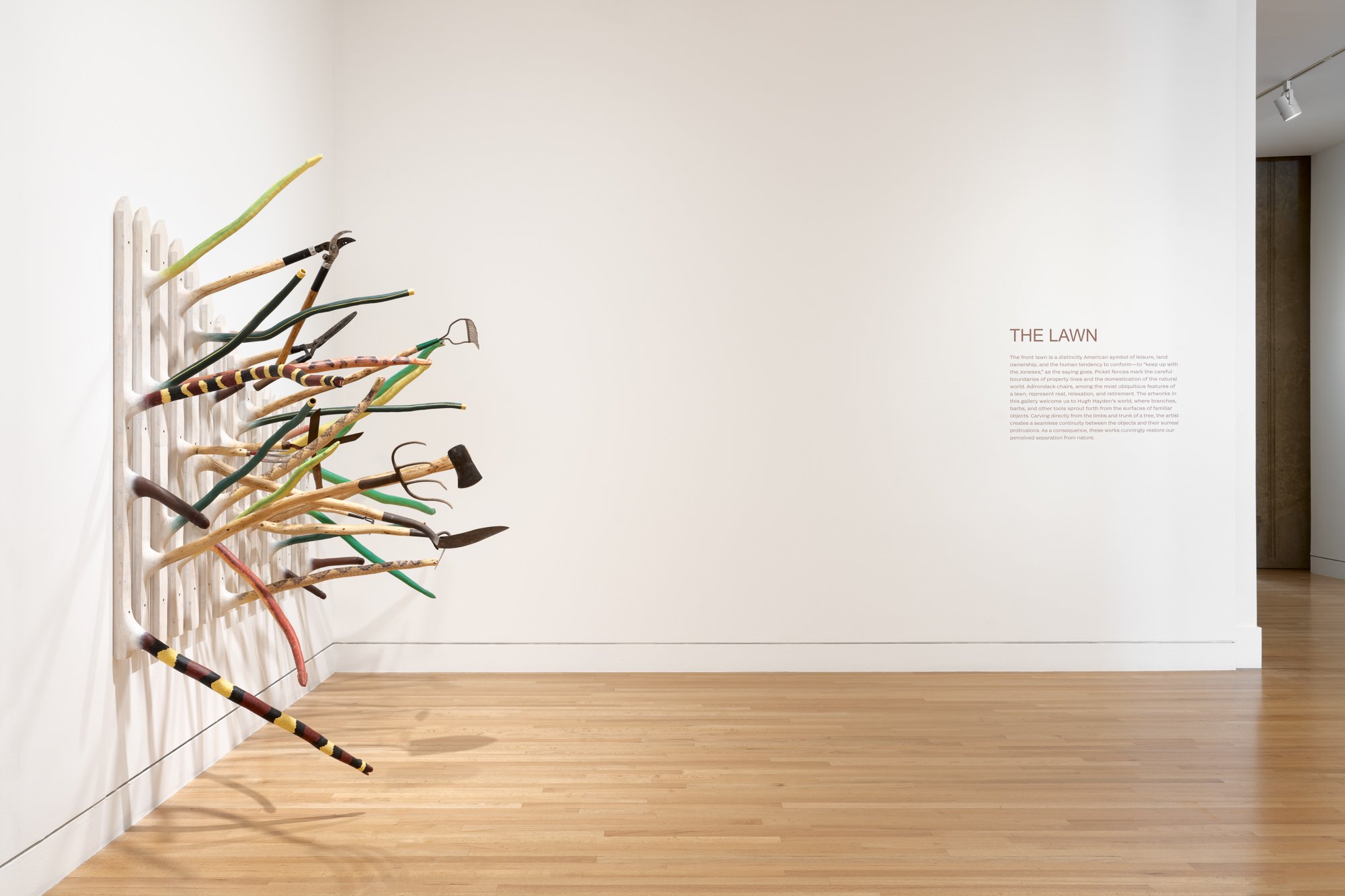 a large wood sculpture on one wall, and vinyl text on another