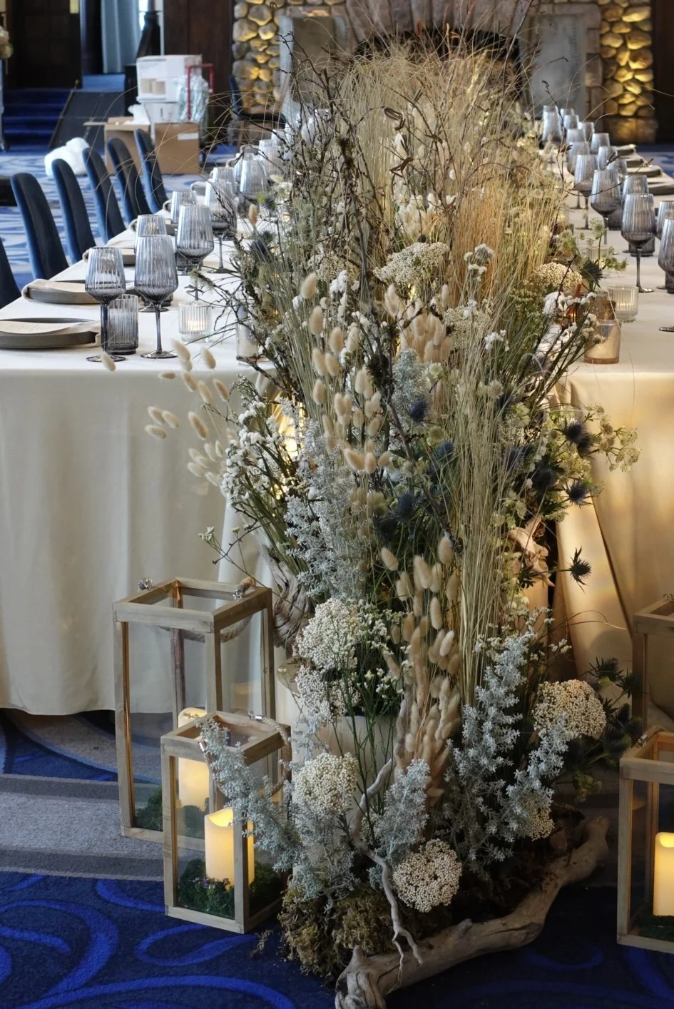 Elegant banquet table with a rustic floral centerpiece and lanterns.