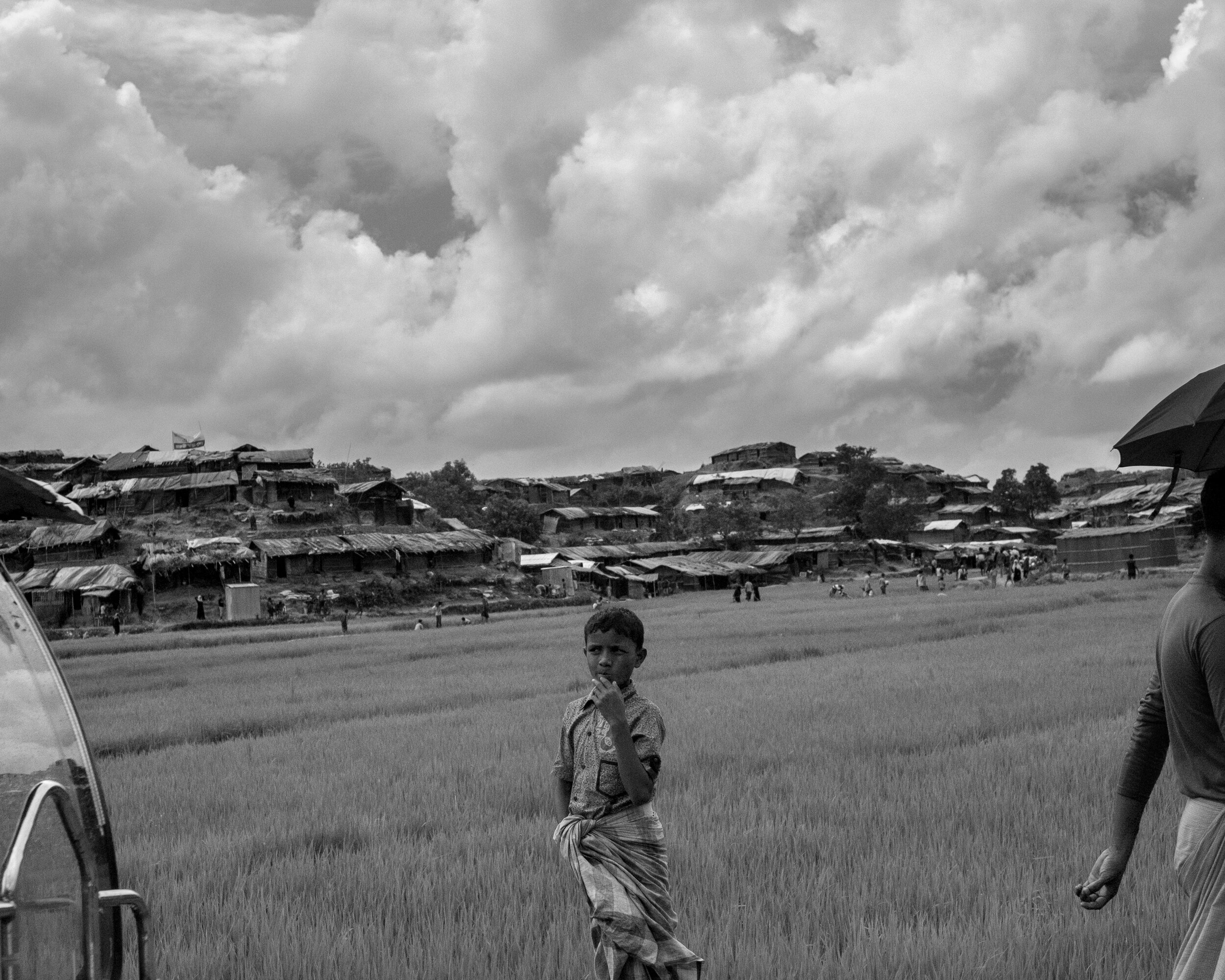  A little boy stands in front of the second largest Rohingya refugee camp in the Cox’s Bazaar area; Balukhali, run by the government and the United Nations.  