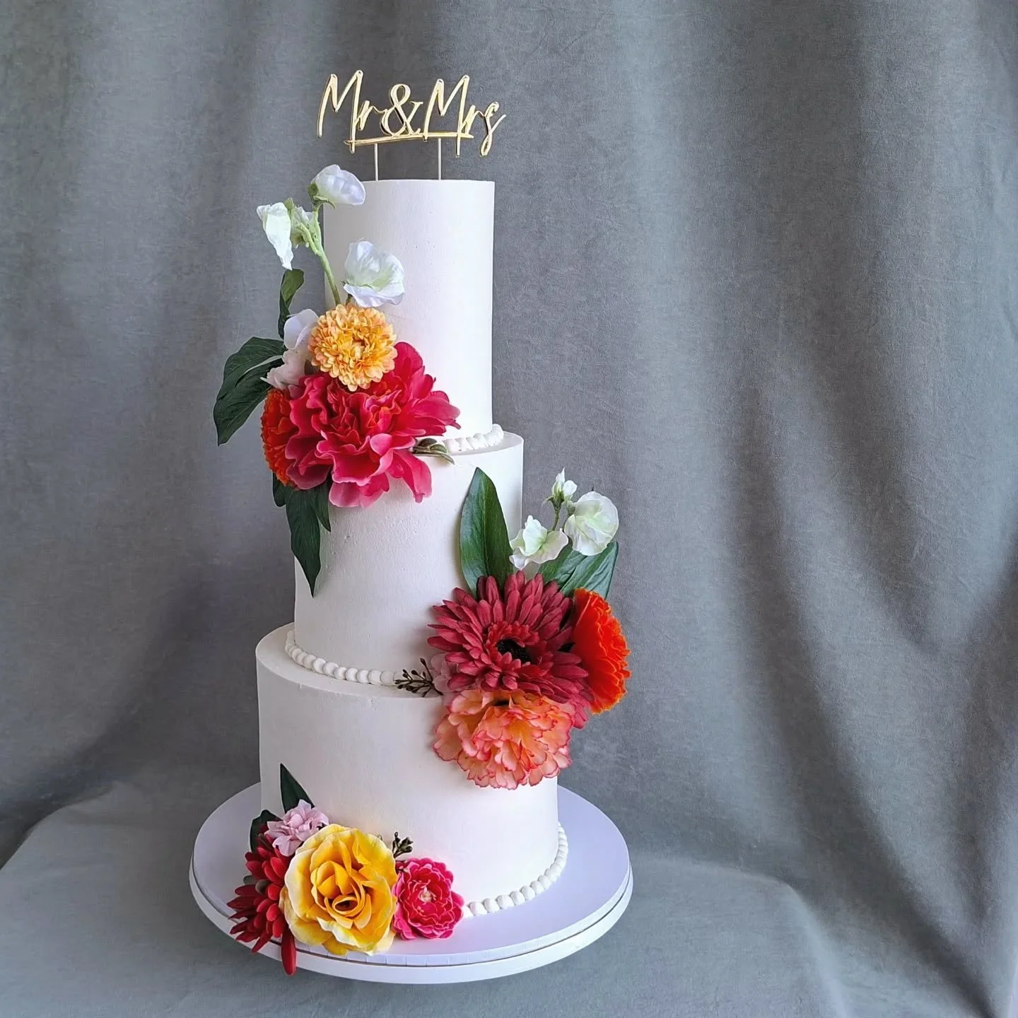 Love a pop of colour! 💛🧡🩷 

Congratulations Mr &amp; Mrs Wood 🍾💍💕

3-tiered smooth white wedding cake
> 4" vanilla cake with lemon curd filling
> 6" chocolate cake filled with chocolate ganache 
> 8" carrot cake with van