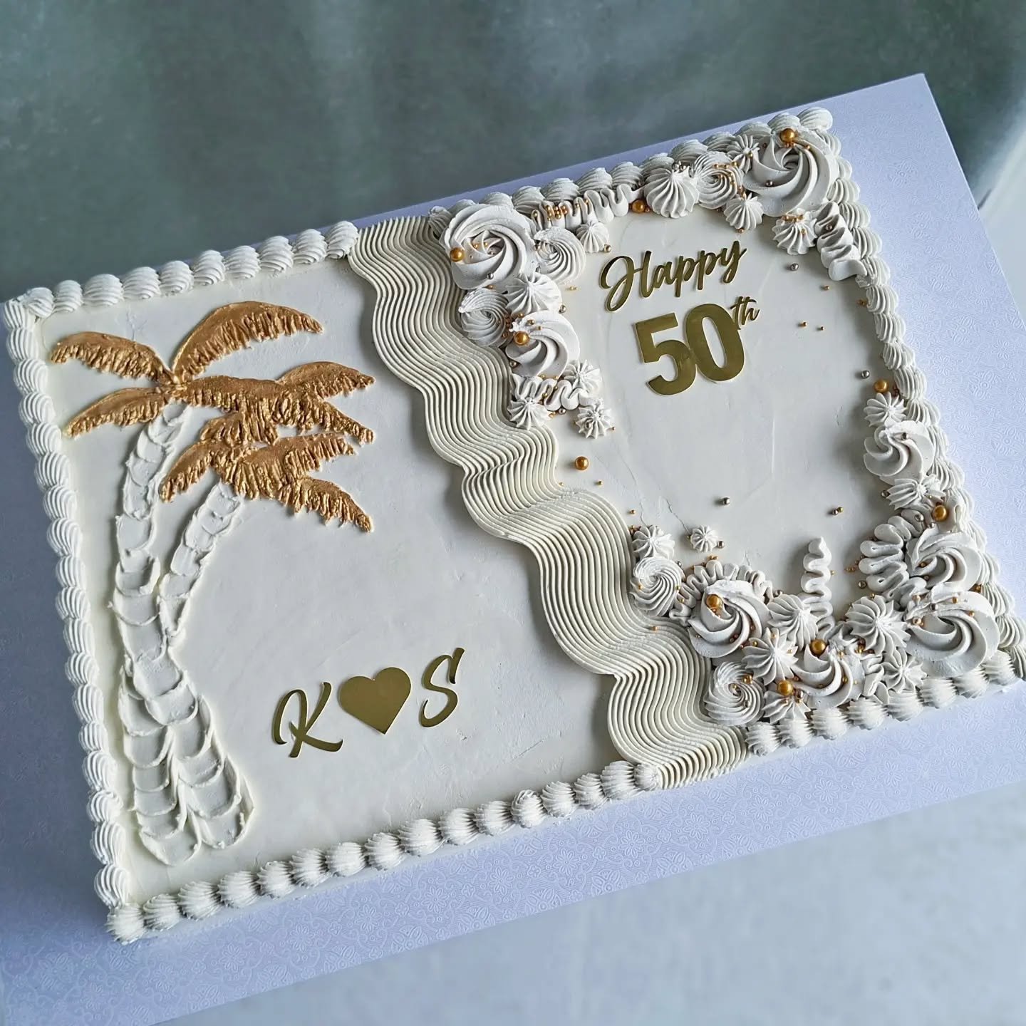 A cake of 2 halves , one side to celebrate an engagement and the other to celebrate a 50th birthday 🌴 💛 🥳

#engagementcake #birthdaycake #taupocakes 
#whiteandgoldcake #celebrationcake
