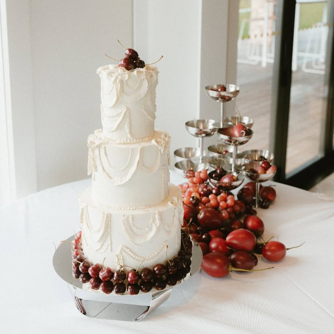 A fun 3-tiered wedding cake with fresh cherries and piped buttercream
