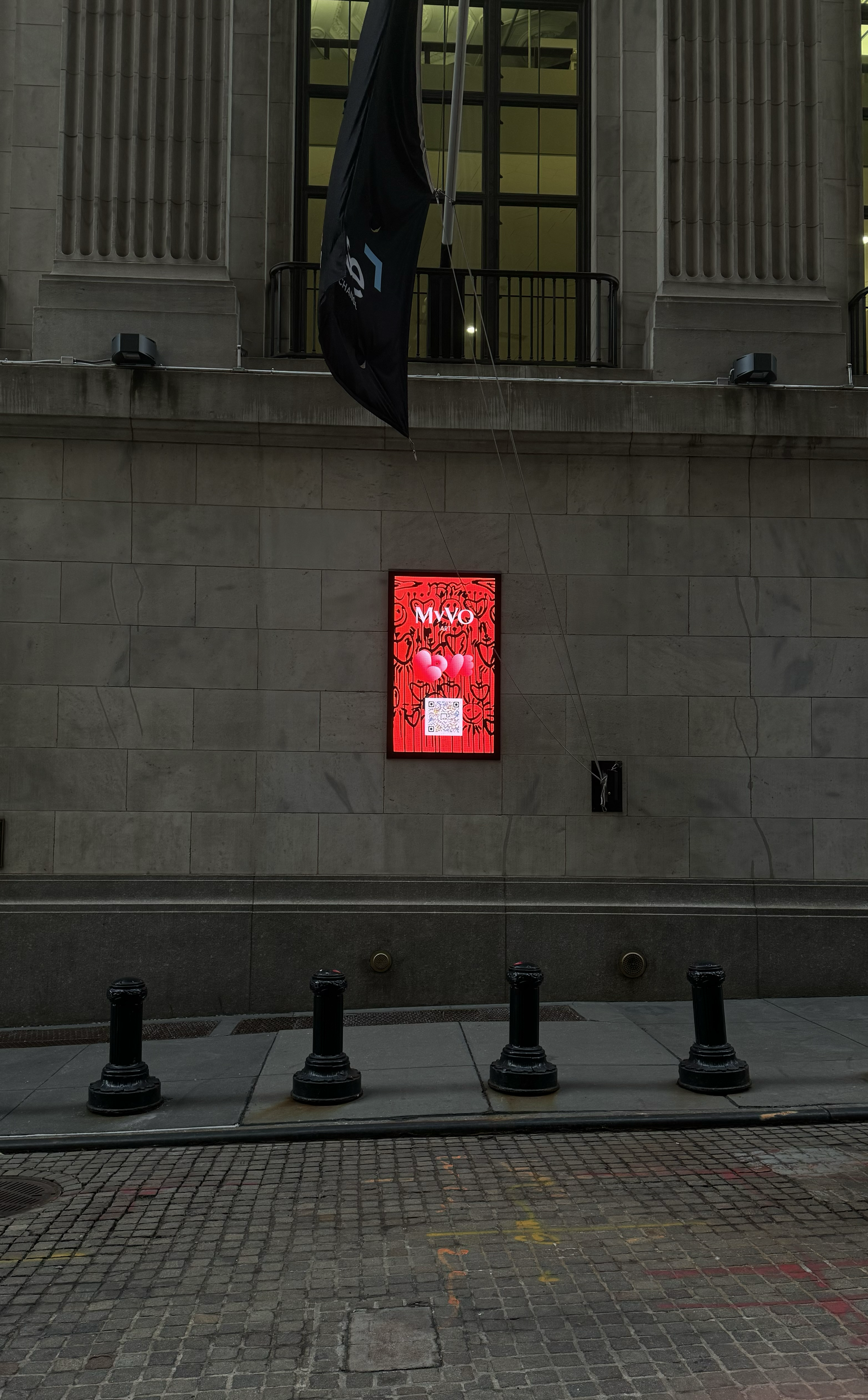 Visual artist, Miana, artwork featured on a screen outside of The New York Stock Exchange building beneath The New York Stock Exchange flag.