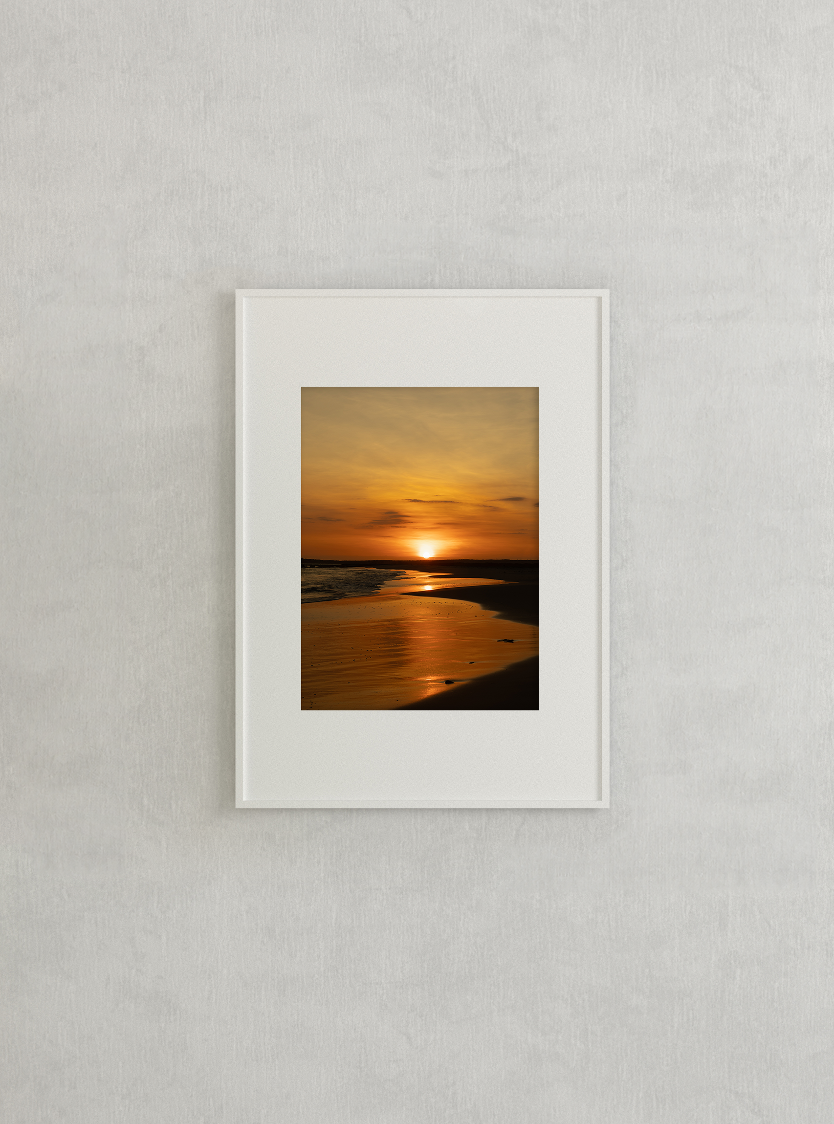 Stunning sunset over a serene beach, with golden reflections on the wet sand and calm waves, perfect for wall art.