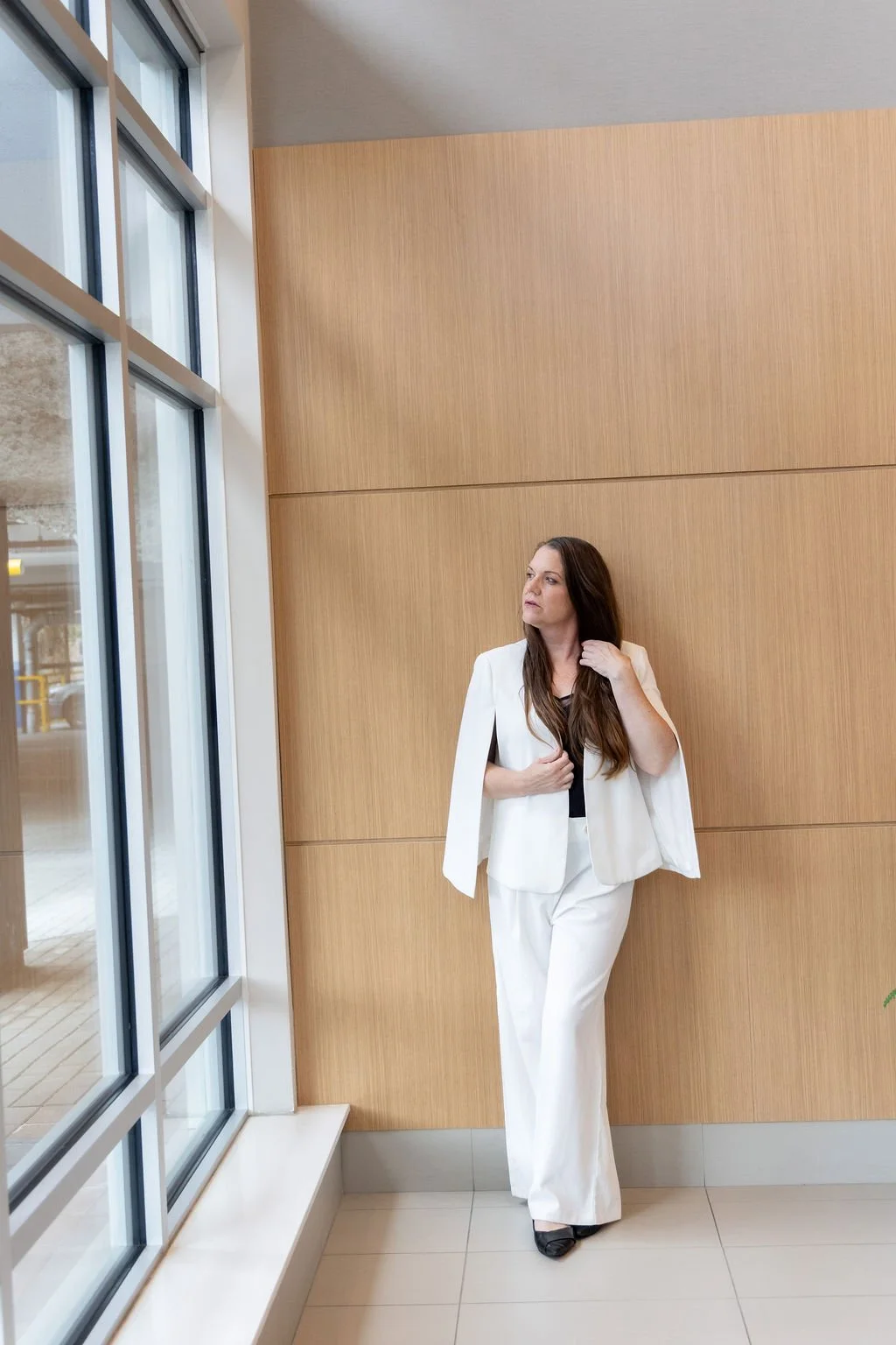 Meghan Simington in a white suit in a sales centre lobby, presale marketing