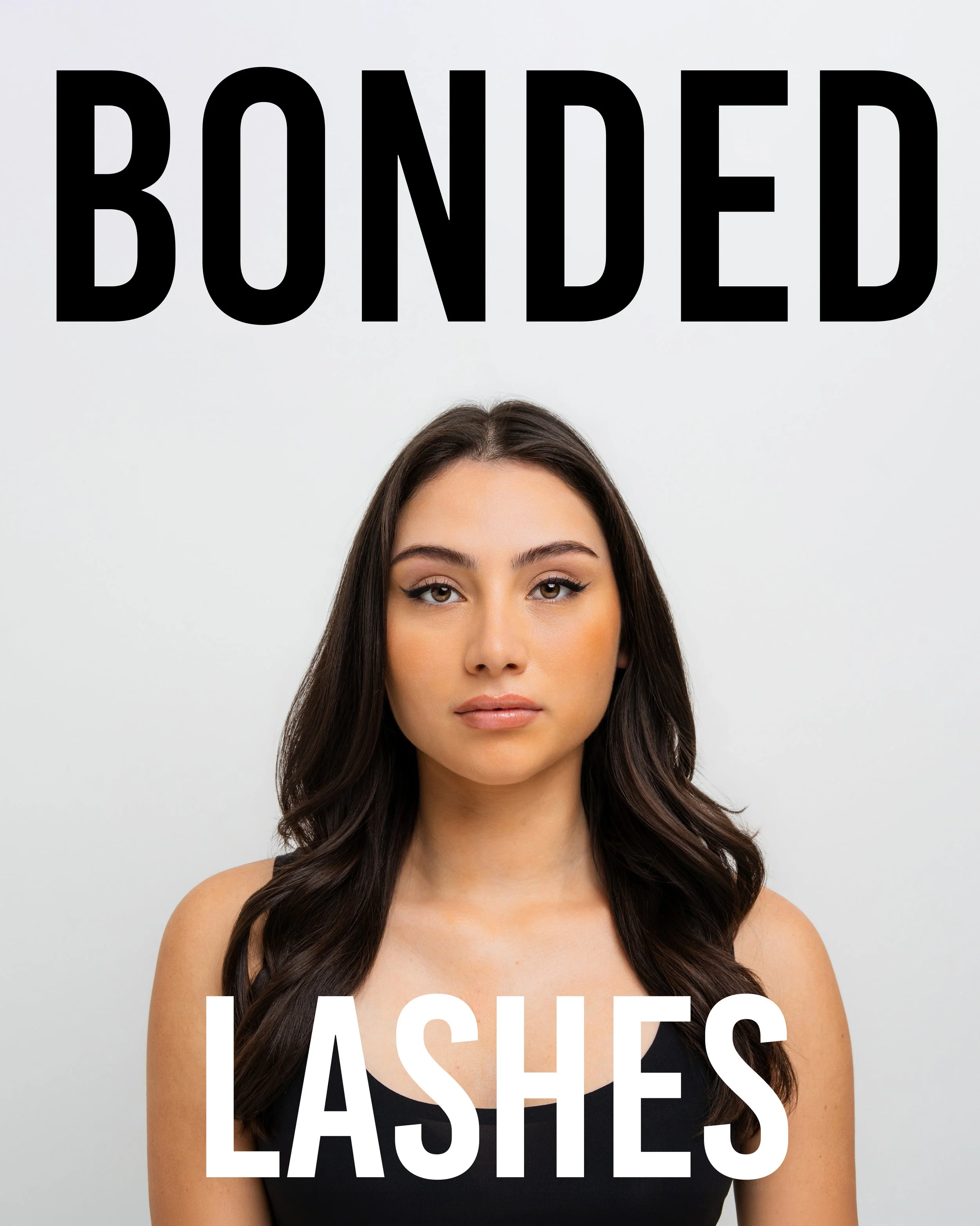 Close-up of a young woman with long dark brown hair, wearing a black strapless top, standing against a light background with the words 'BOUNDLESS EASE' overlaid in large black and white text.