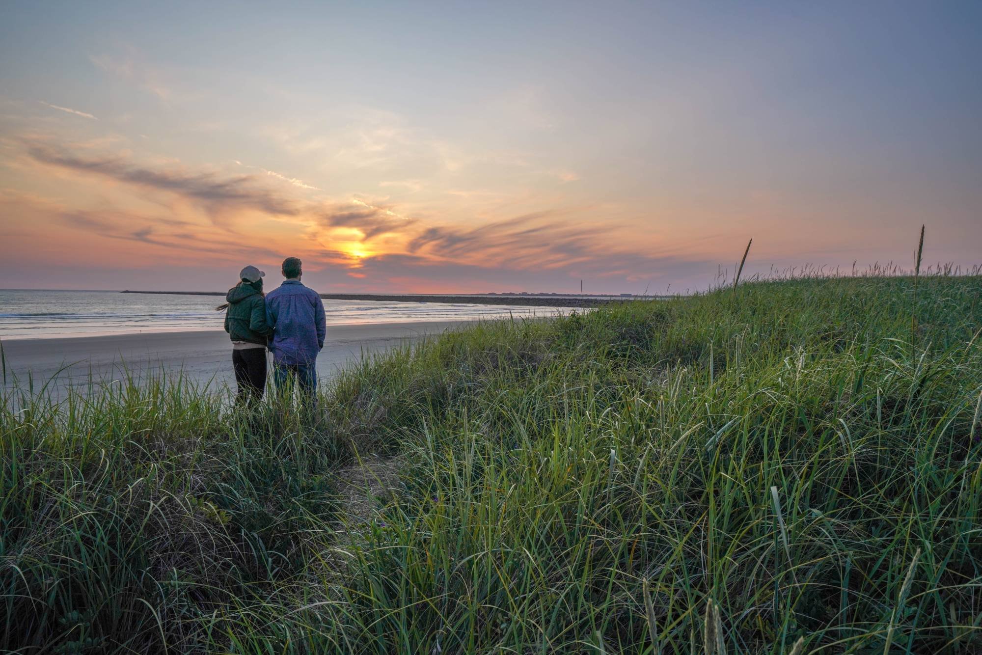 Couple watching sunset over the jetty