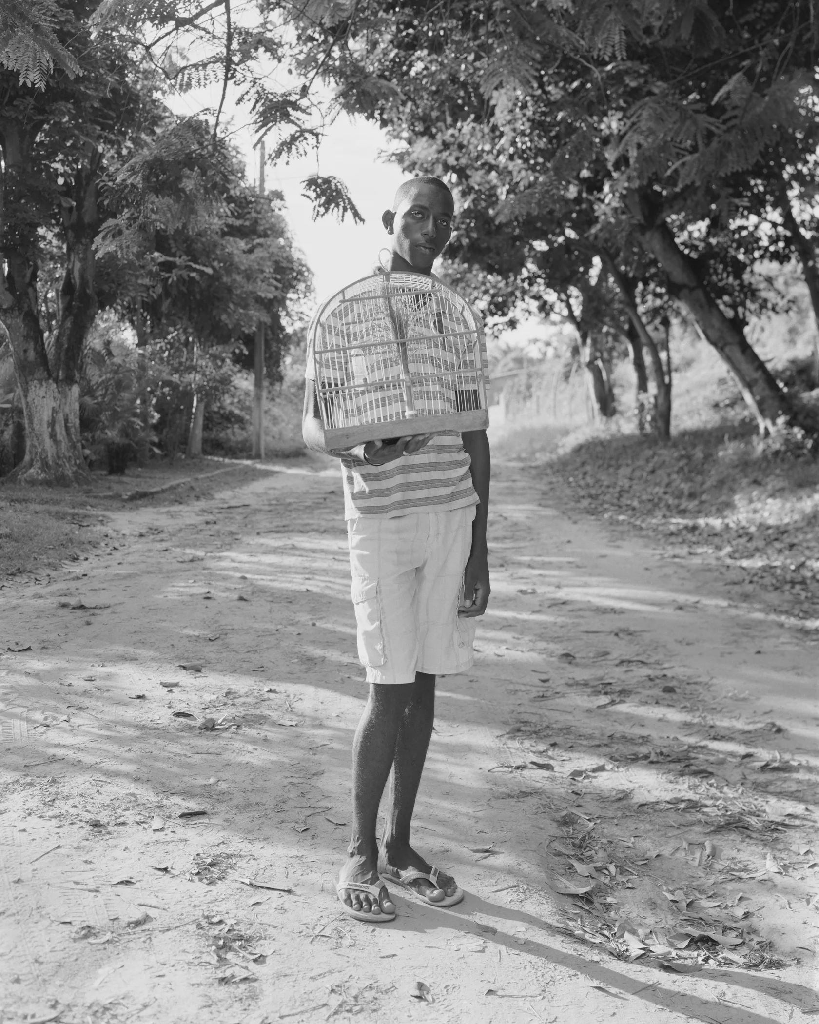 Anderson Silva standing with birdcage, March, 2014, Itaparica, Brazil. 2014/2018