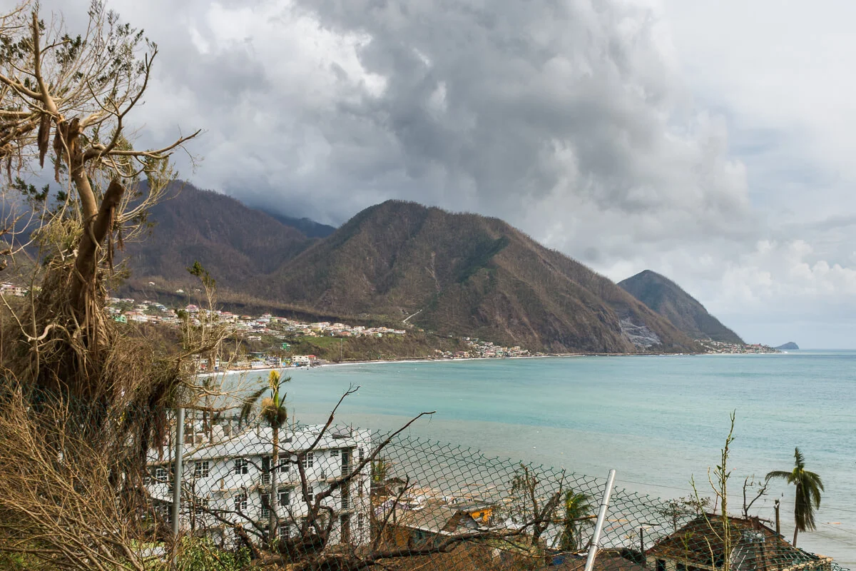 This view was representative of most of Dominica’s landscape in the days that immediately followed Hurricane Maria. I took this photo on the morning after. Note the dead mountainsides and the damaged roofs.