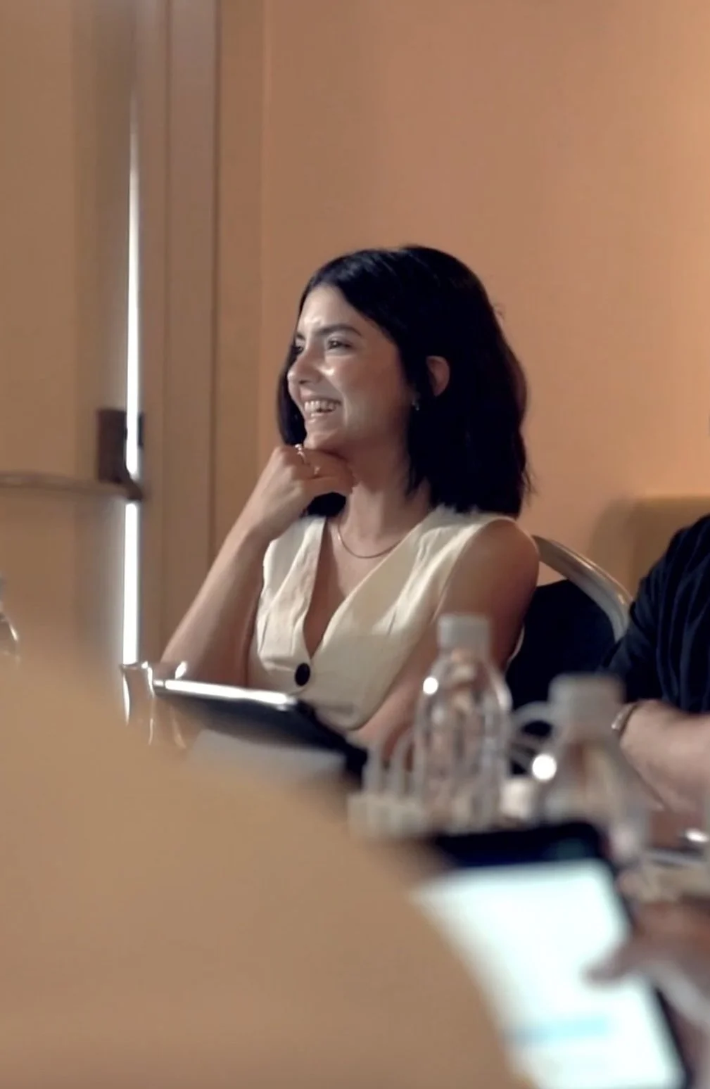 Fulden Dehneli smiling and seated at a meeting table. multi-award-winner turkish industrial designer