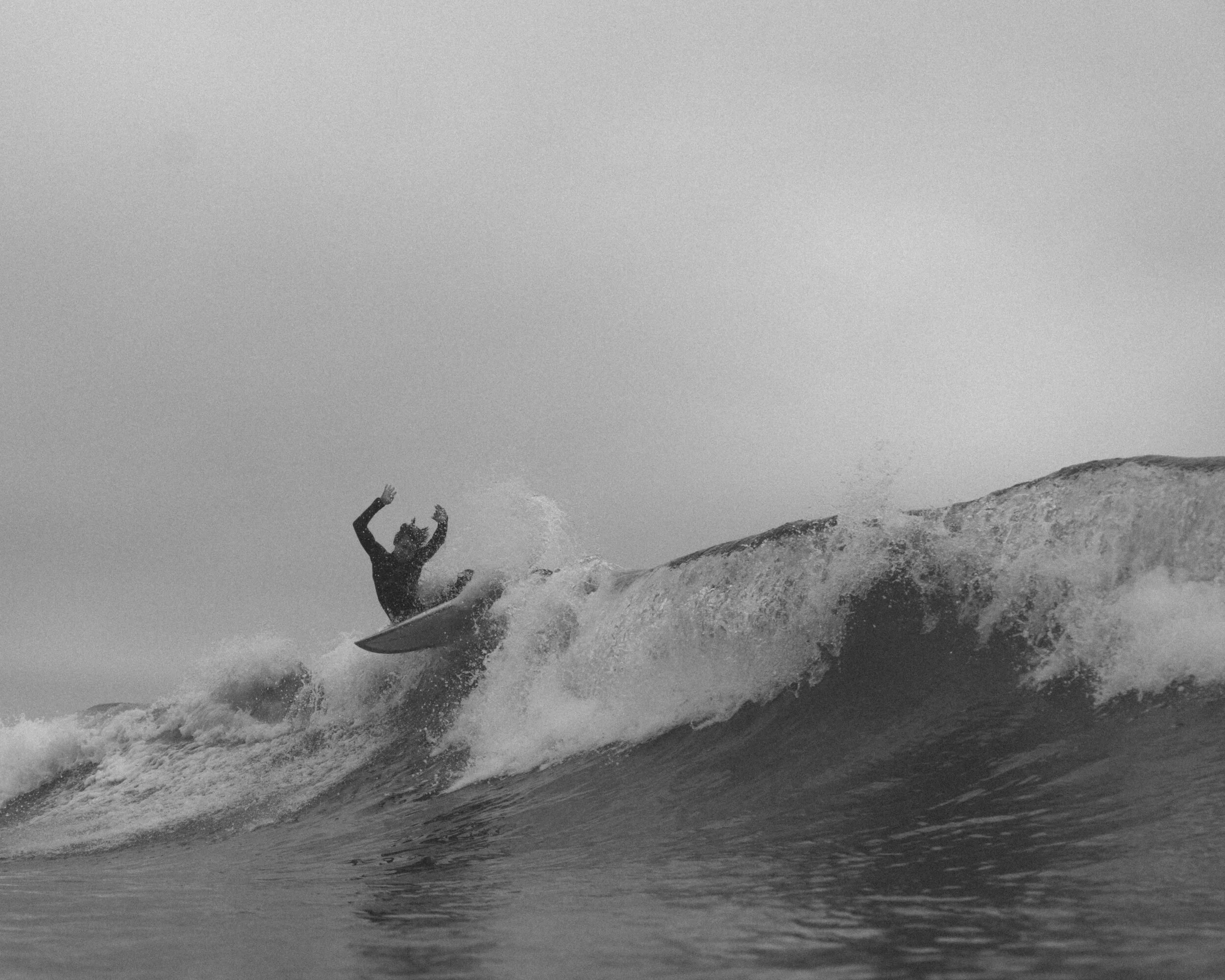 Person surfing on a wave in the ocean.