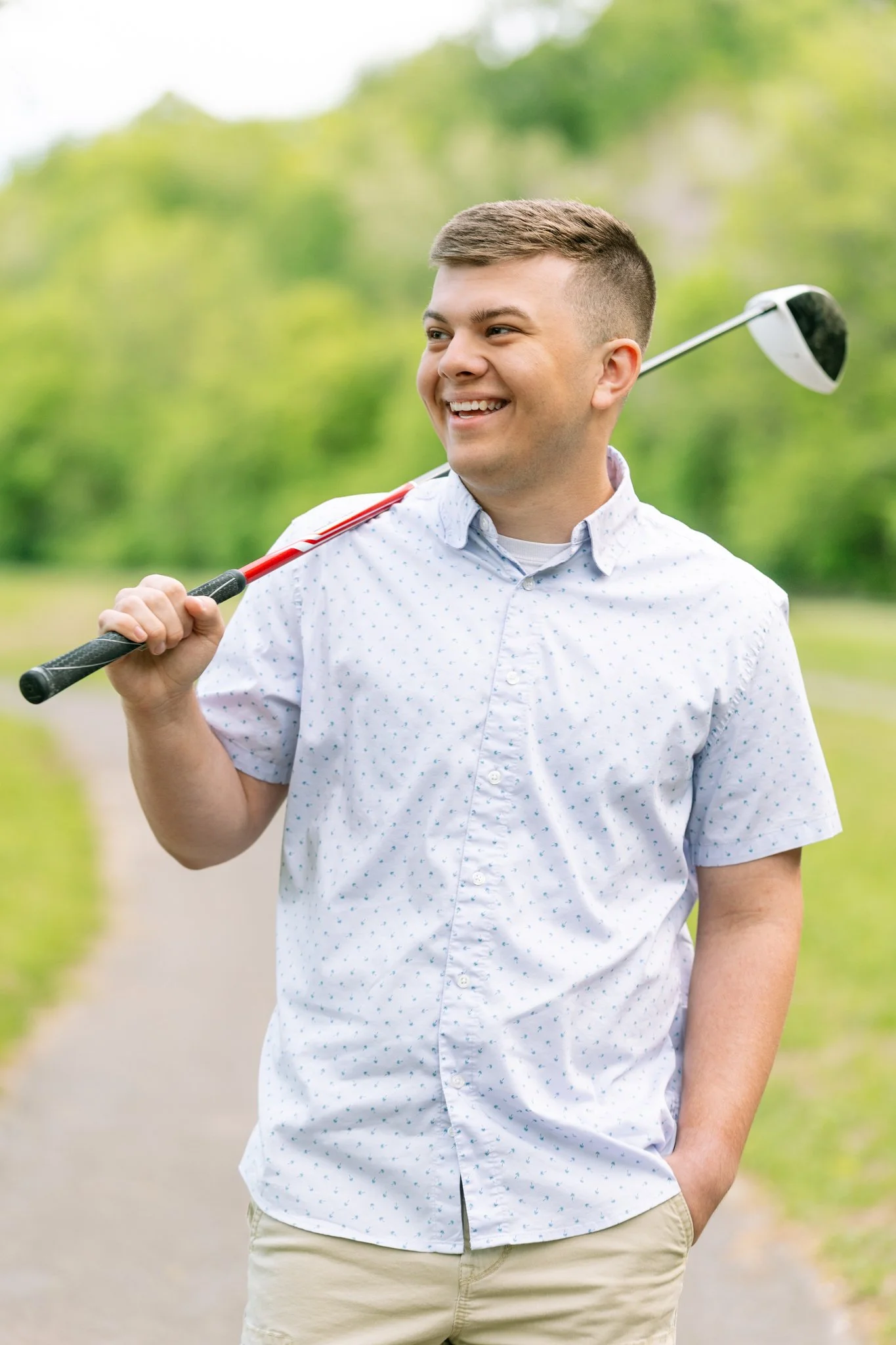 A senior male posing with a golf club during a Tampa, FL senior photo session.