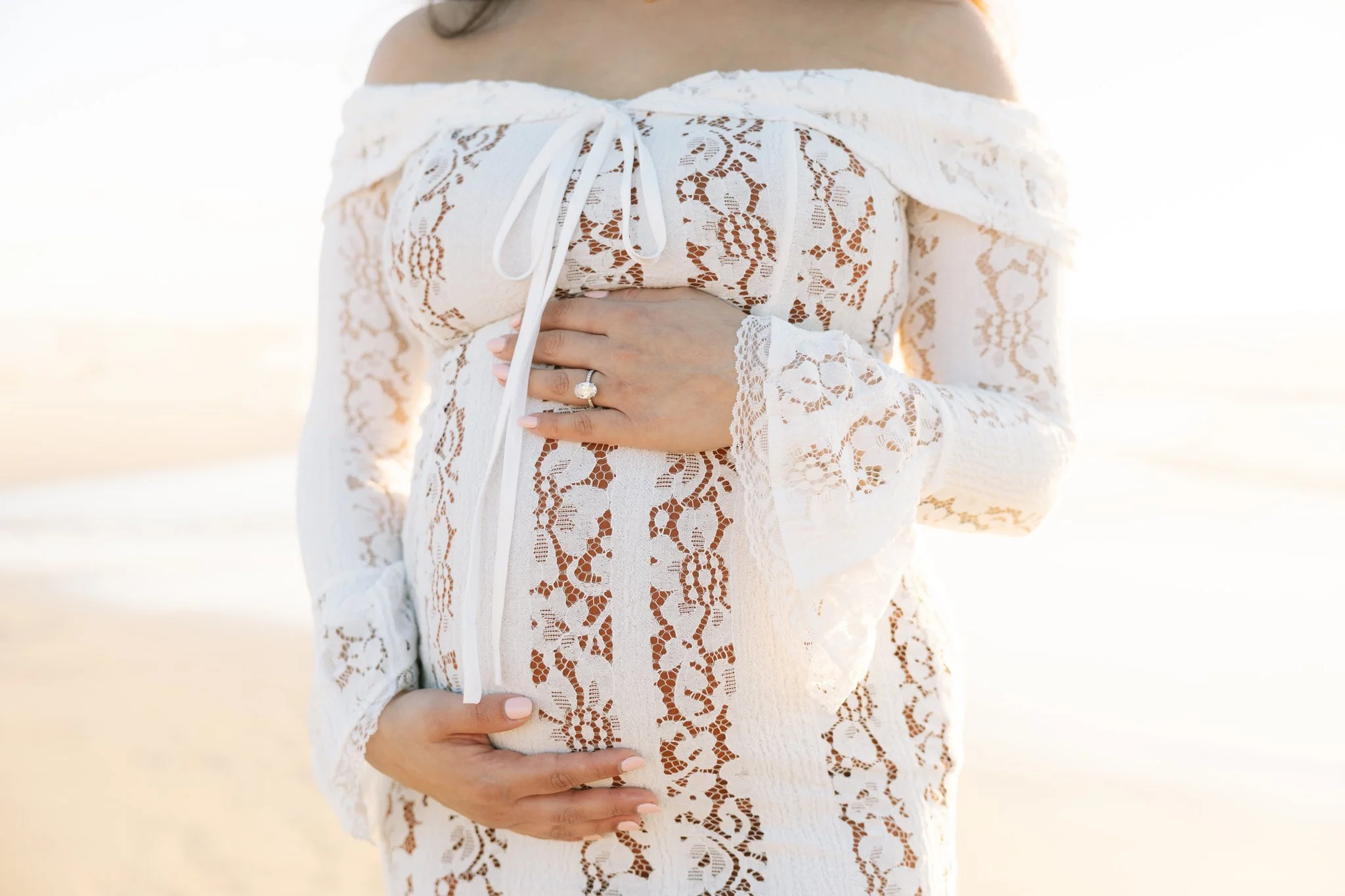 Close up photo of a woman holding her pregnant belly as she poses for a maternity portrait in Tampa, FL.