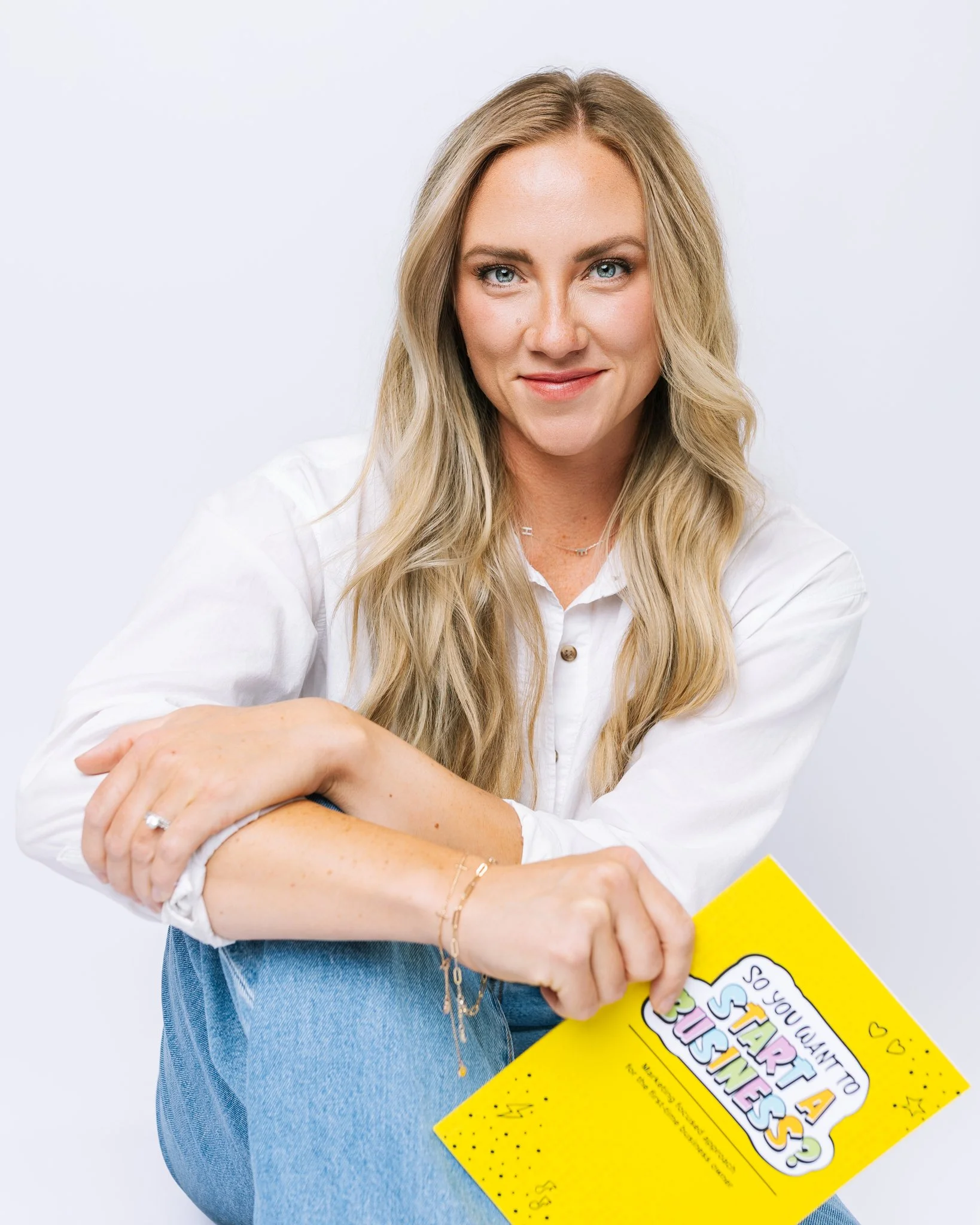 An author posing with her book during a Tampa, FL branding photo session.