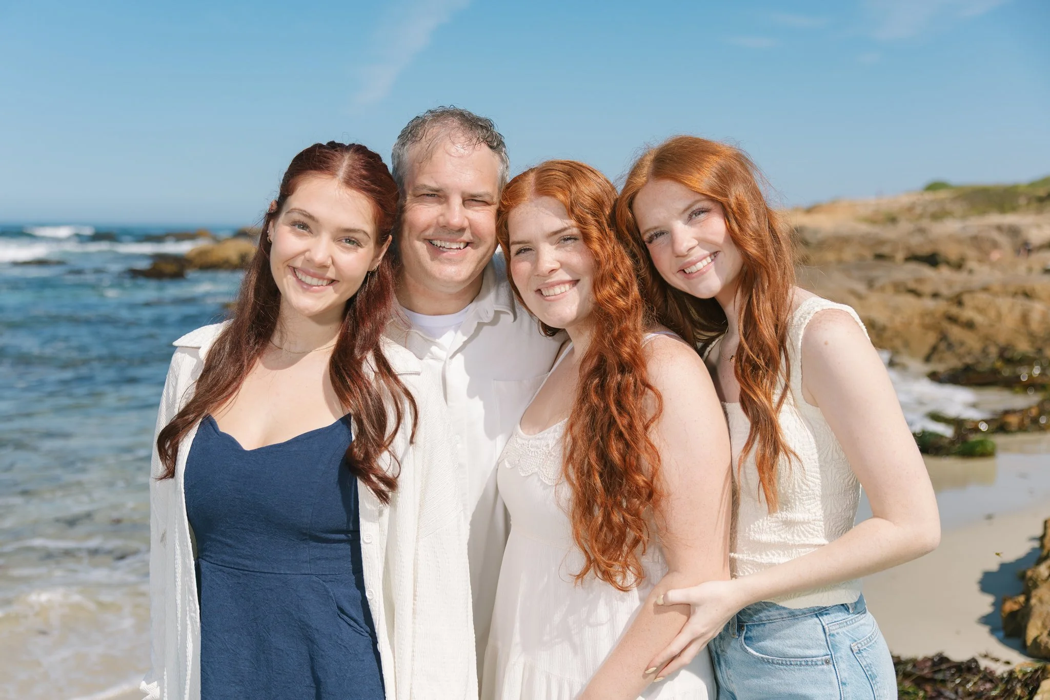 Family smiling on the beach during a Tampa Bay family photo session.