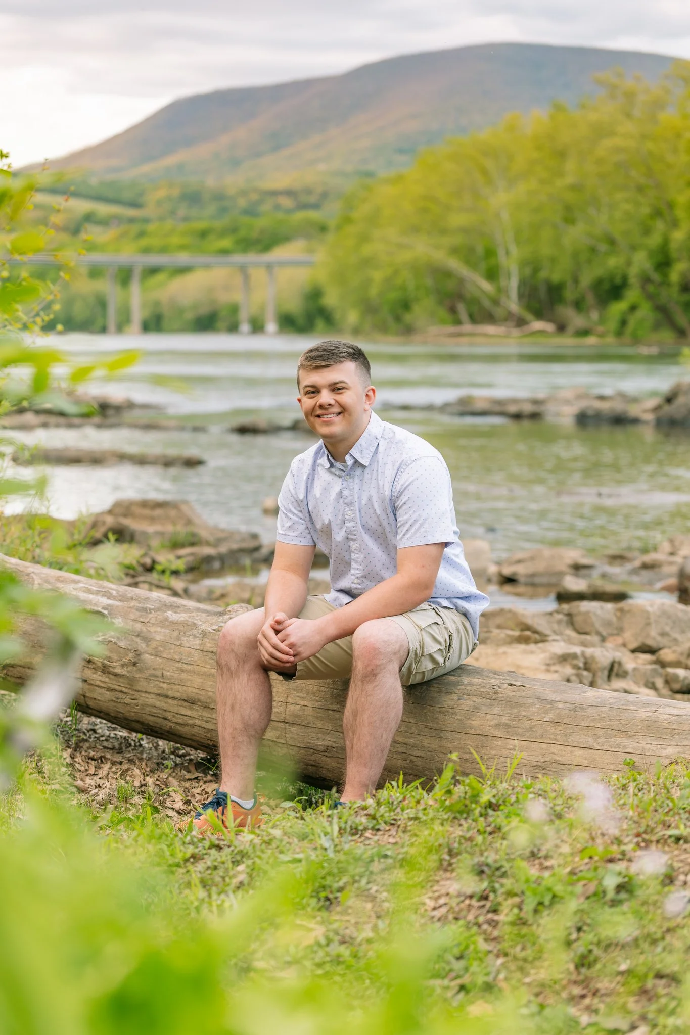 A male graduate posing for a senior photo session by the water in Tampa, FL.