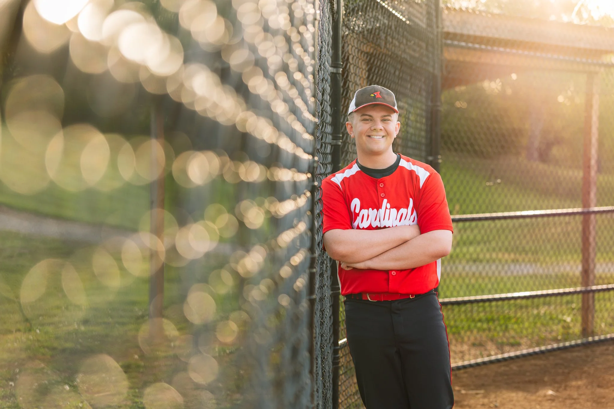 A senior graduate posing for a senior photo session in Tampa, FL wearing his baseball uniform.