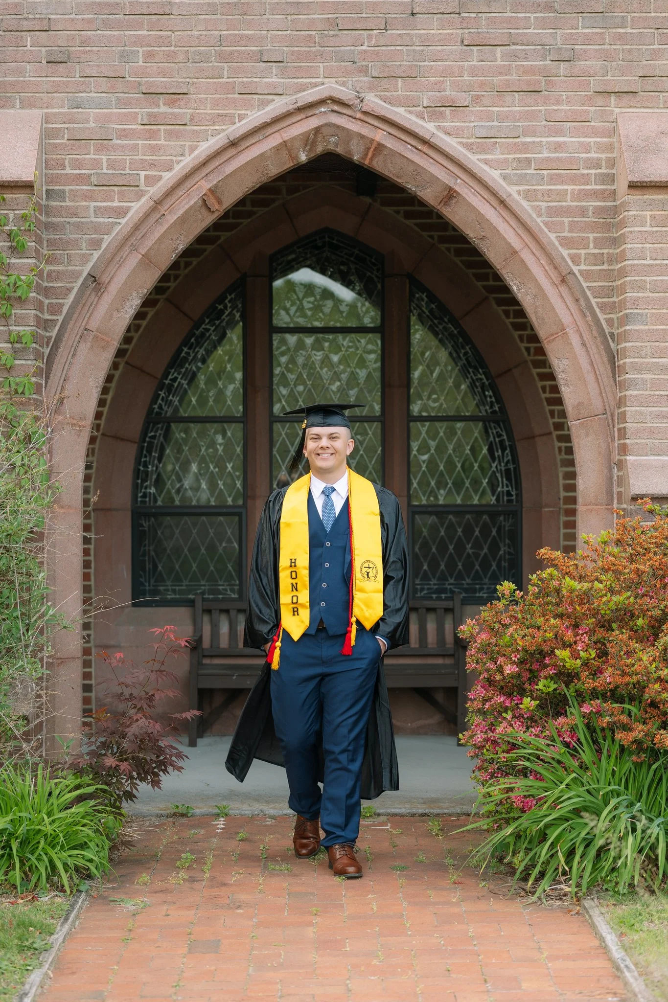 A senior graduate in his cap and gown posing for a senior photo session in Tampa, FL.